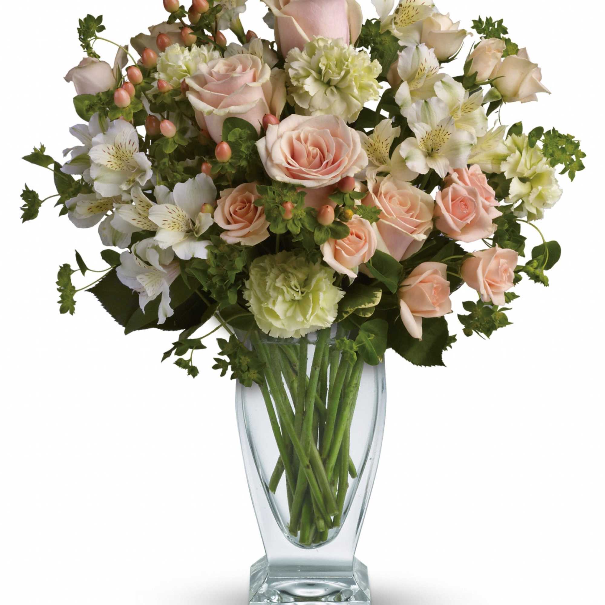 Vase arrangement of peach roses, green carnations, and white alstroemeria in a clear glass vase
