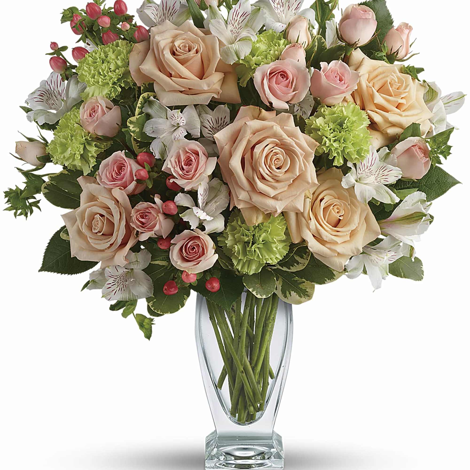 Peach roses, pink spray roses, green carnations, and white alstroemeria in a clear glass vase