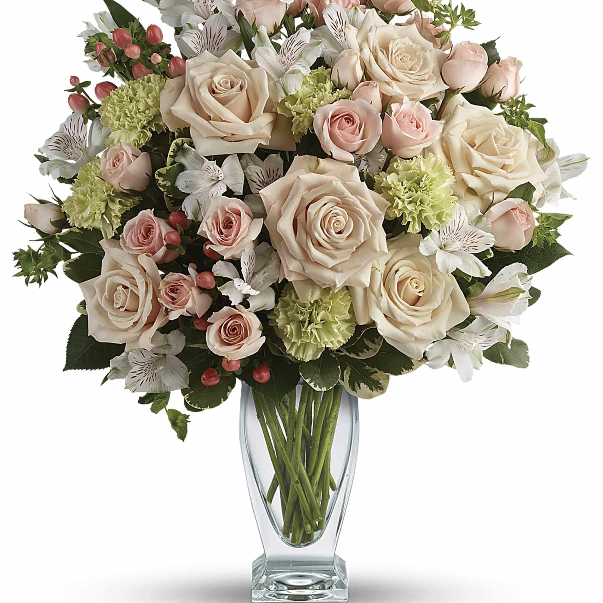 Tall glass vase filled with blush roses, green carnations, and white alstroemeria with pink accents.