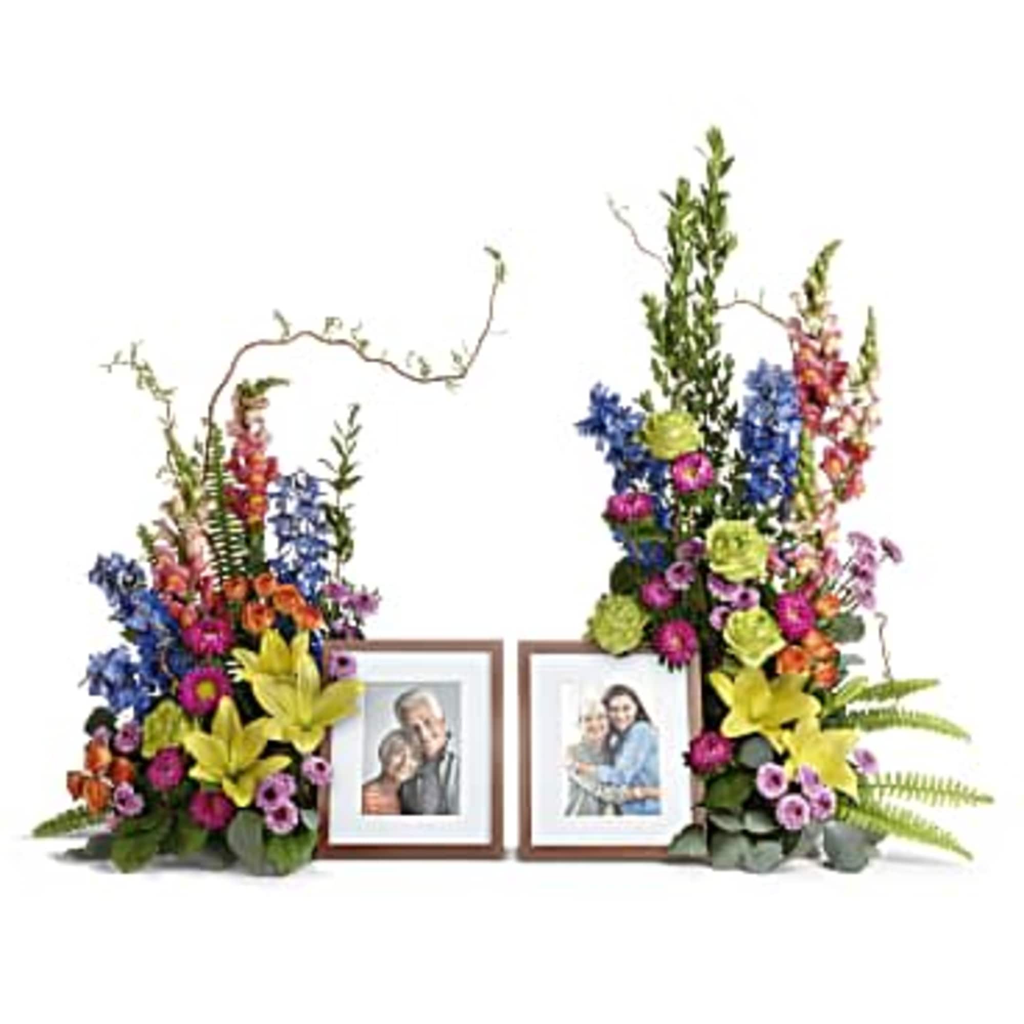 Pair of colorful tall floral arrangements framing two wooden photo frames
