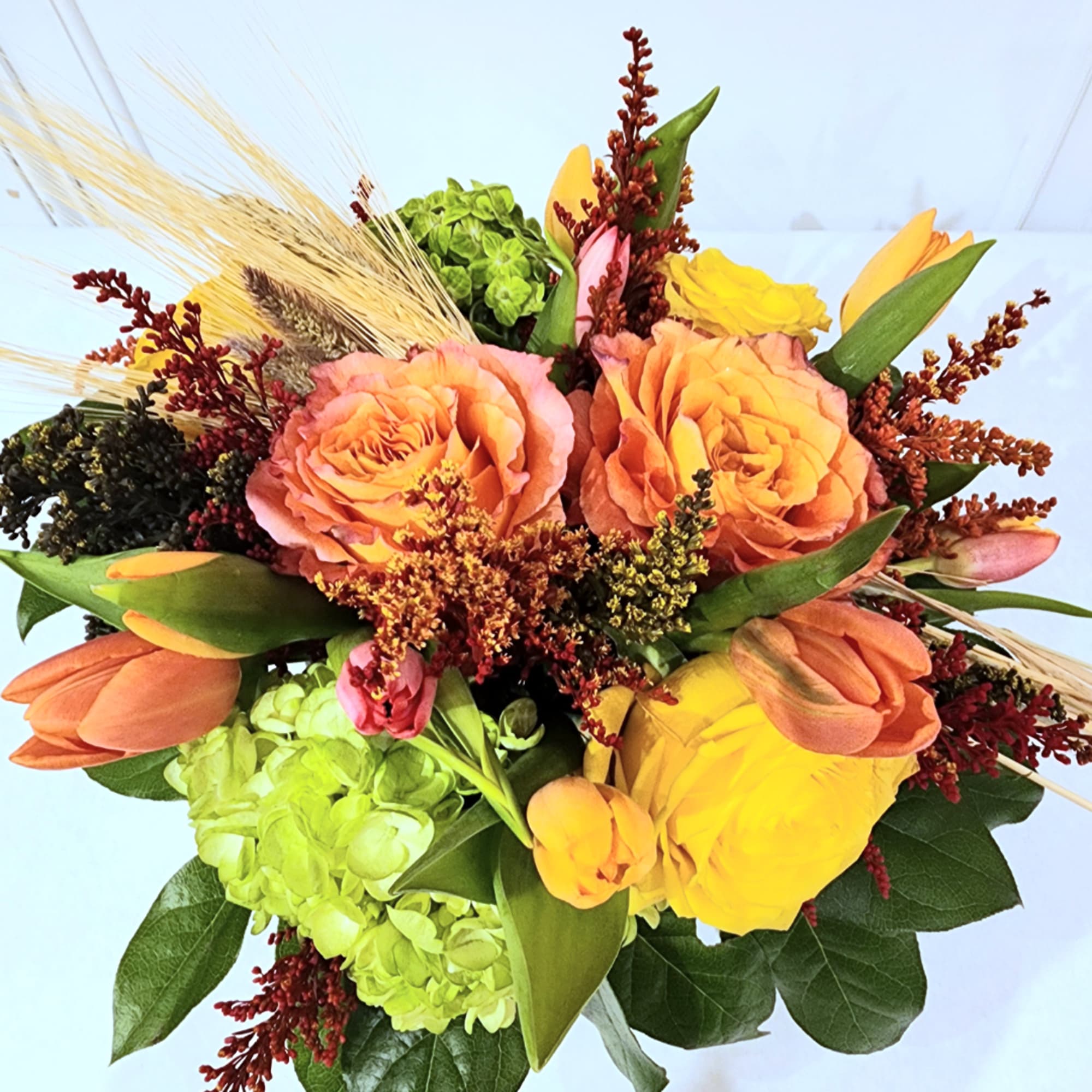 Bouquet of peach roses, yellow tulips, and green hydrangeas