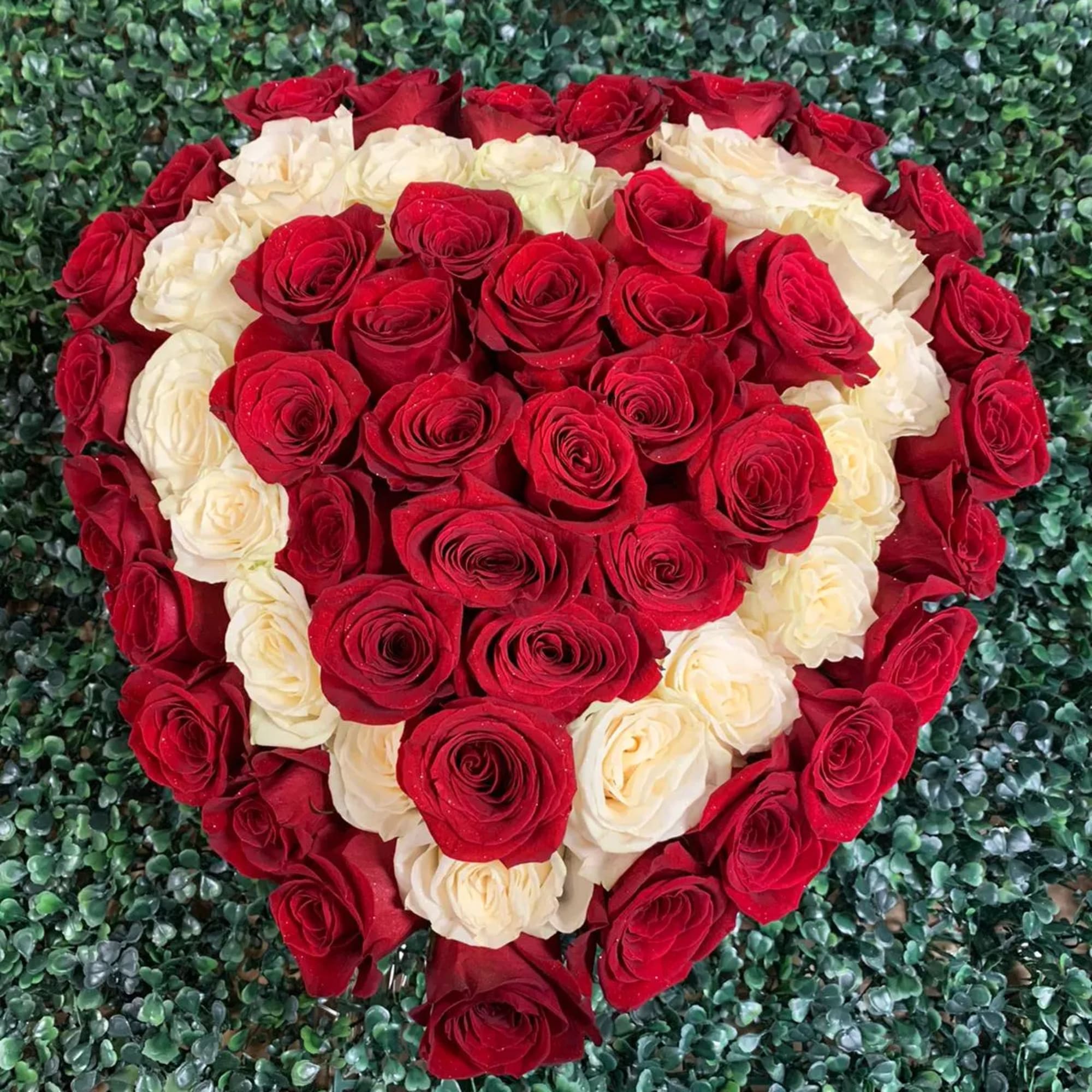 Heart-shaped arrangement of red and white roses