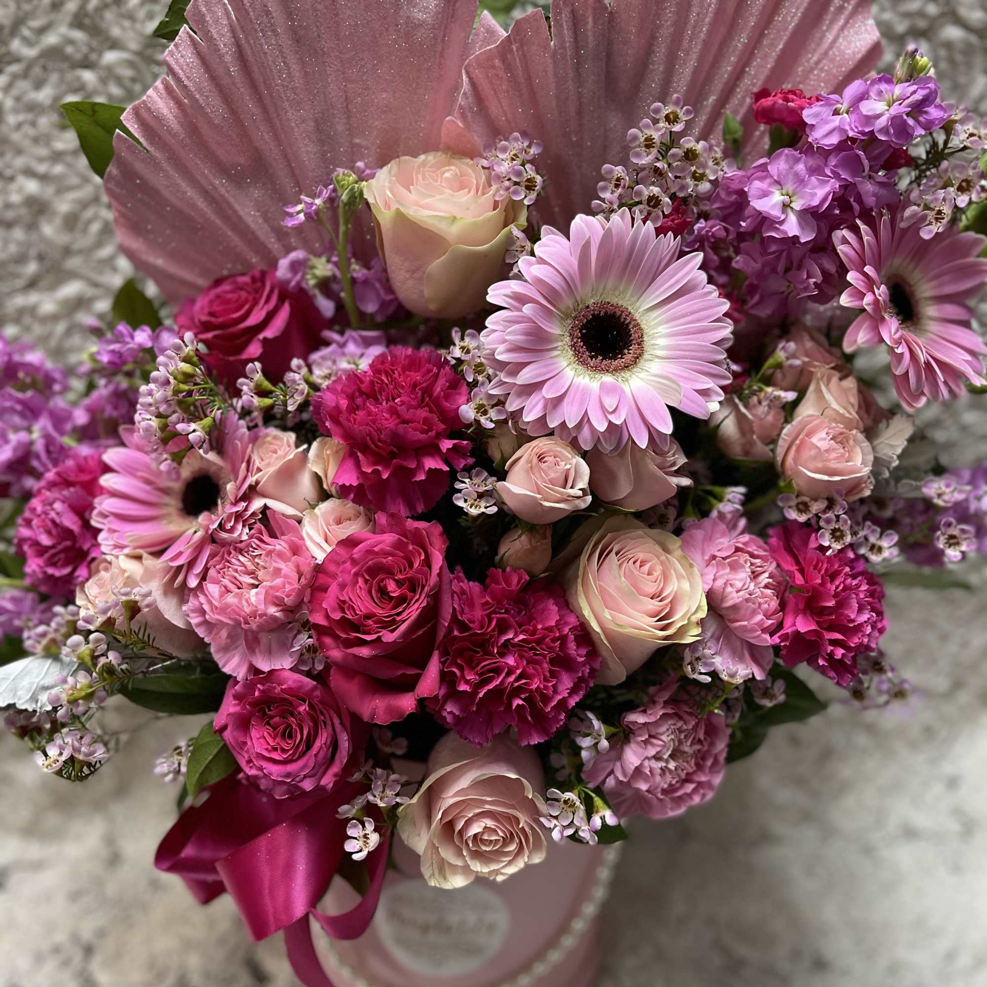 Pink and lavender bouquet with roses, gerbera daisies, and carnations in a pink box