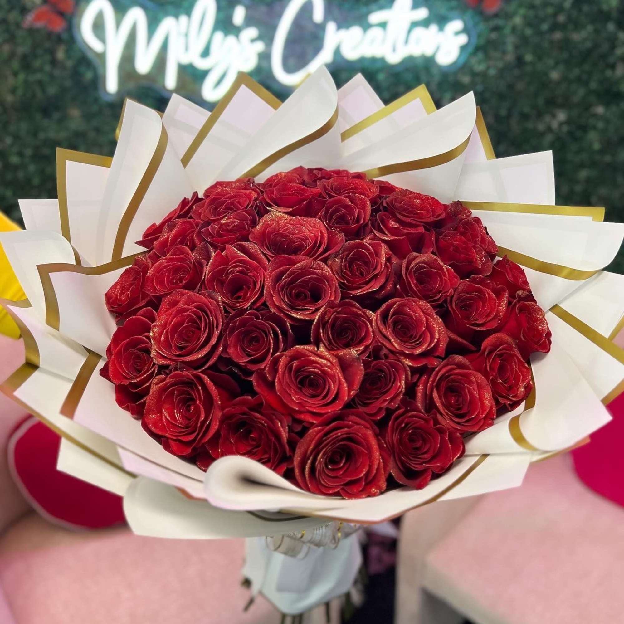 Bouquet of red roses wrapped in white and gold paper