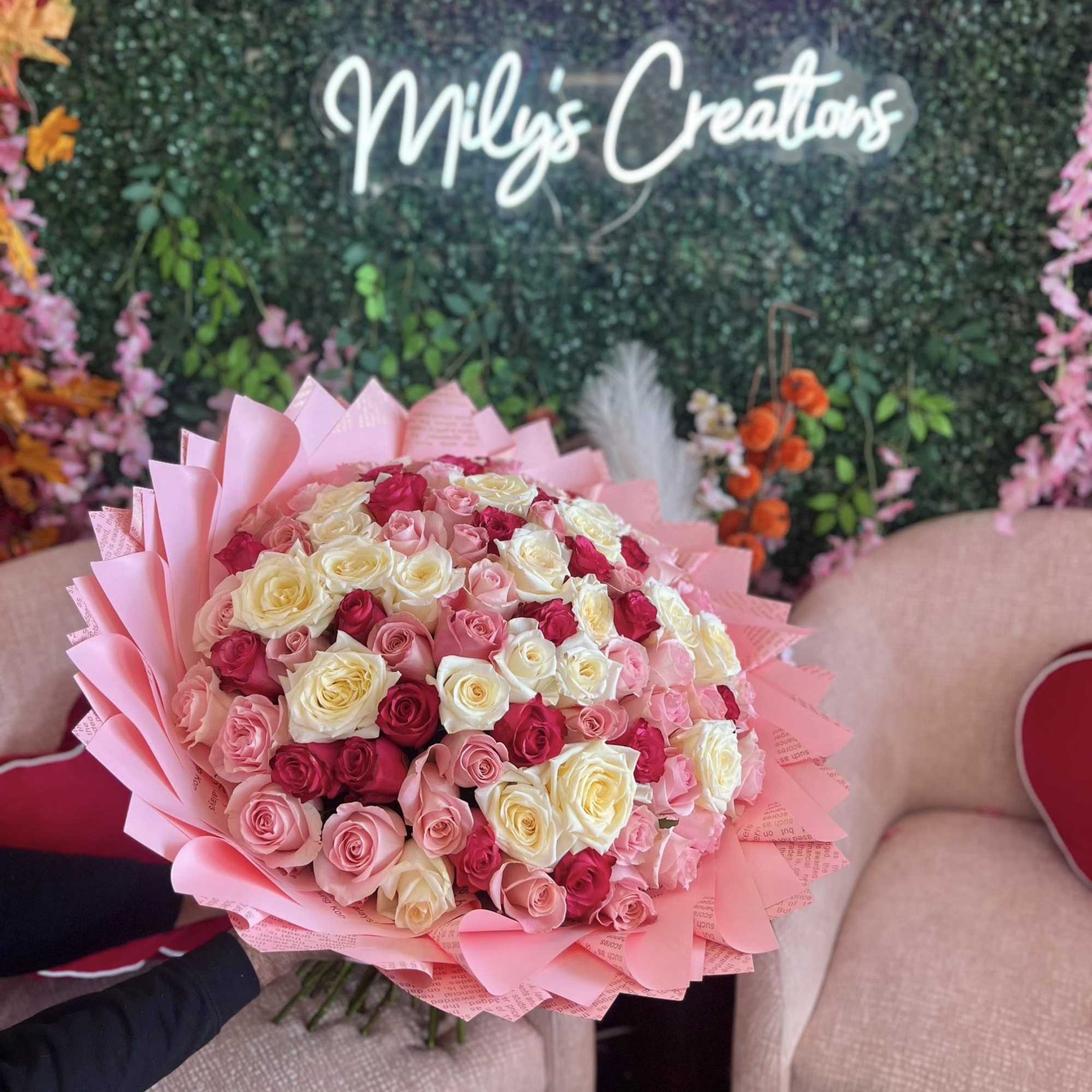 Large bouquet of pink, white, and red roses wrapped in pink paper