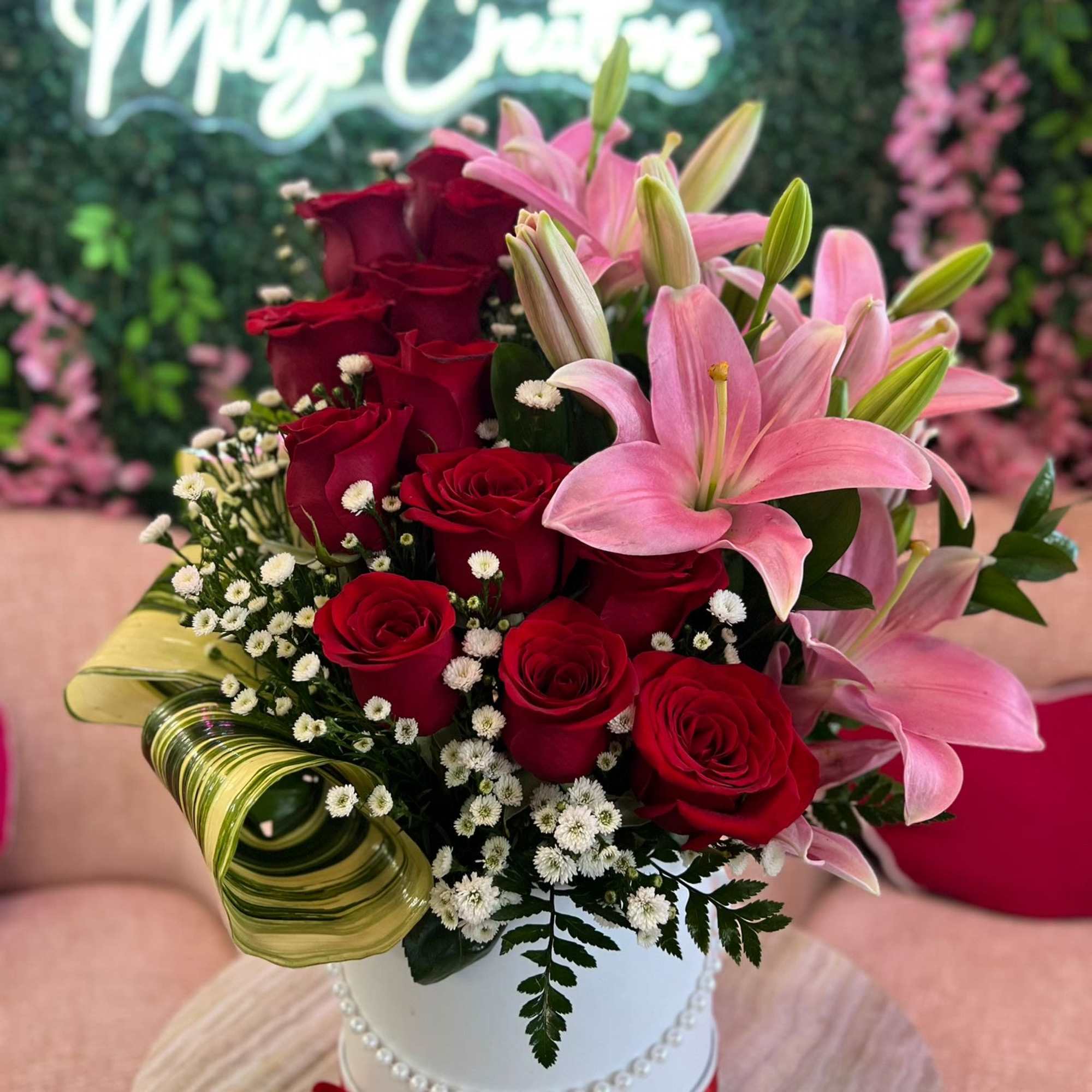 Bouquet of red roses and pink lilies in a white hatbox