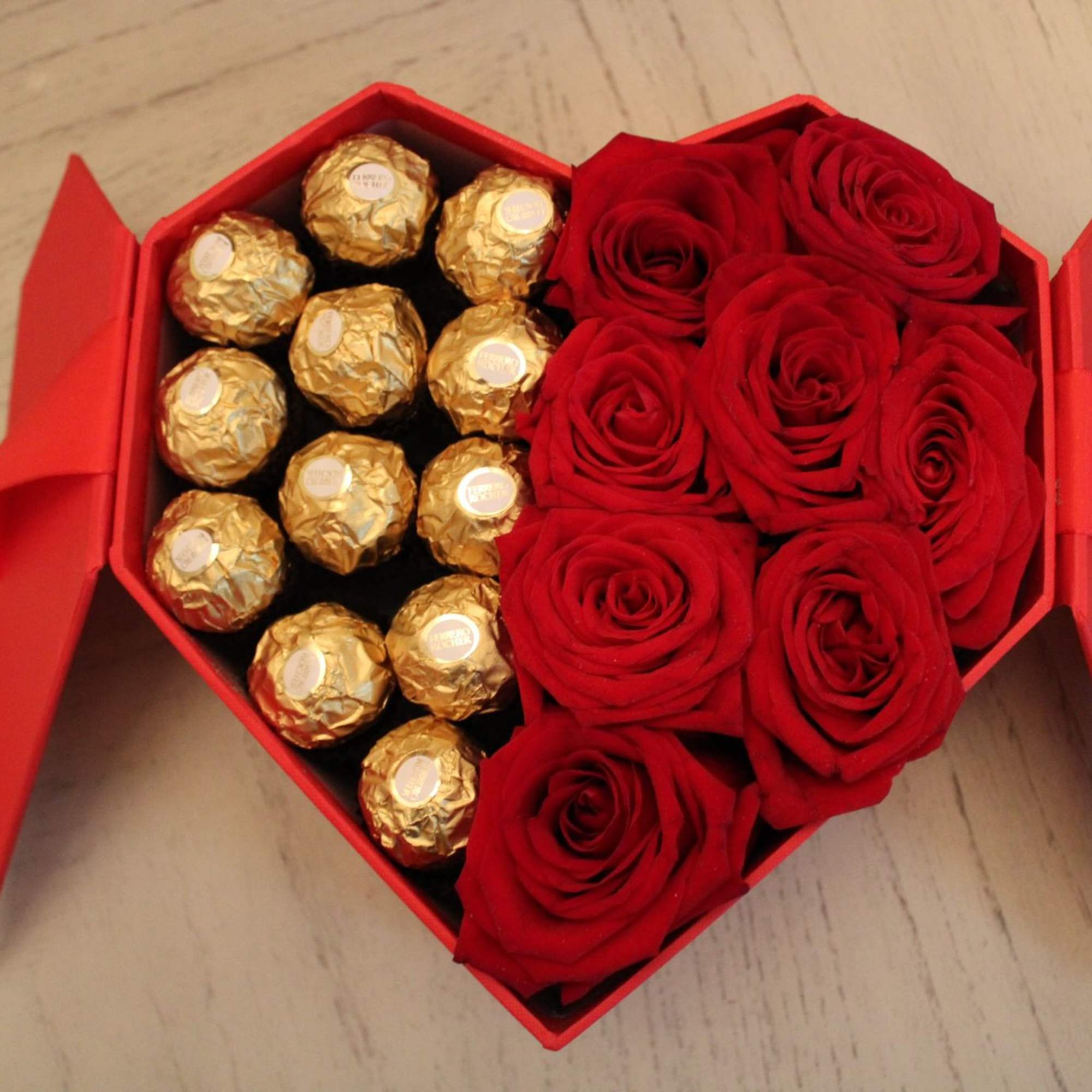 Heart-shaped red box with roses and gold-wrapped chocolates