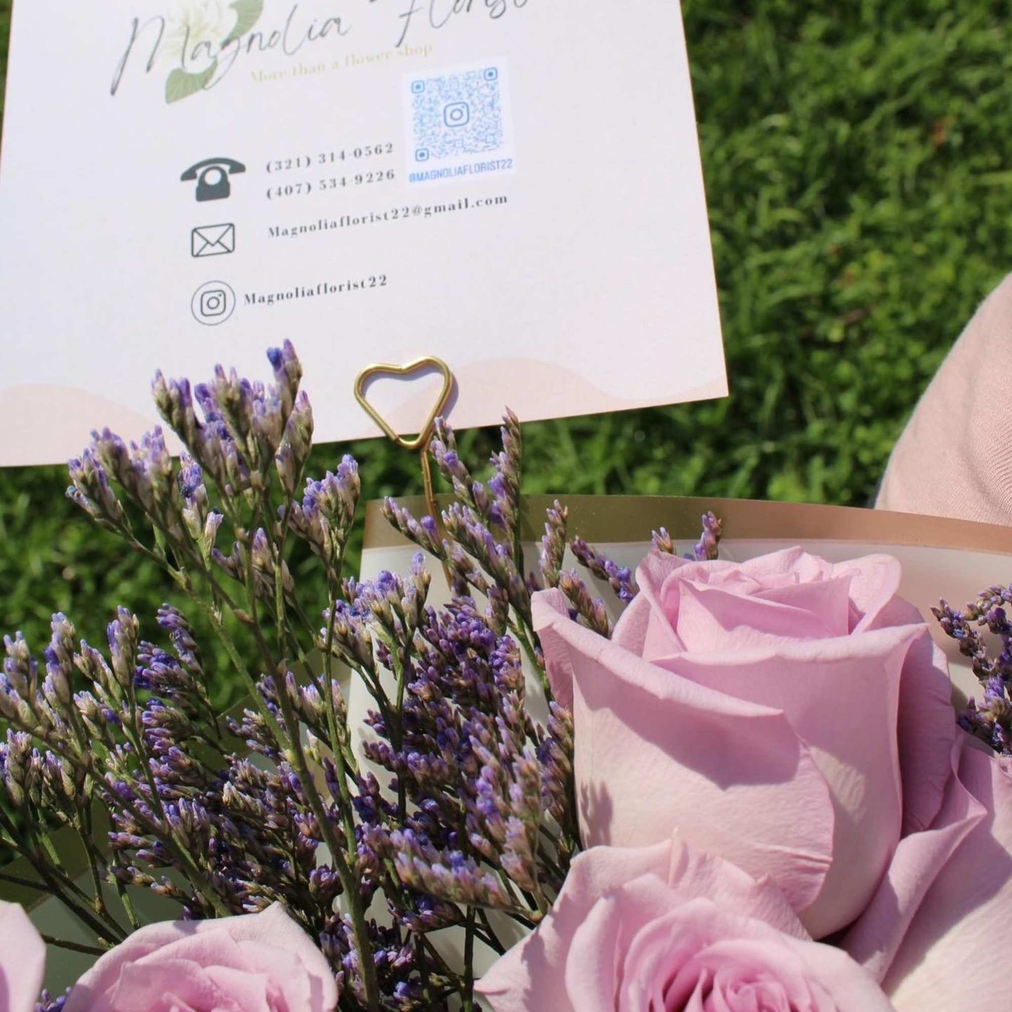 Pink roses with purple filler flowers and a florist card clip