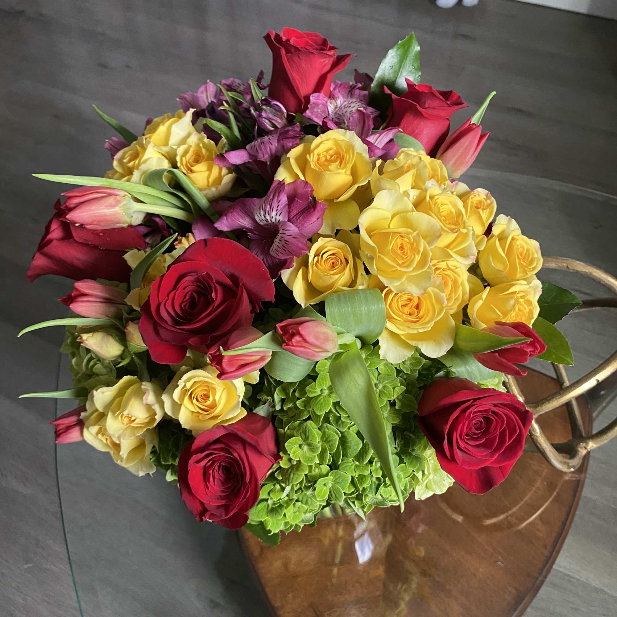 Bouquet of red and yellow roses with pink tulips and purple flowers