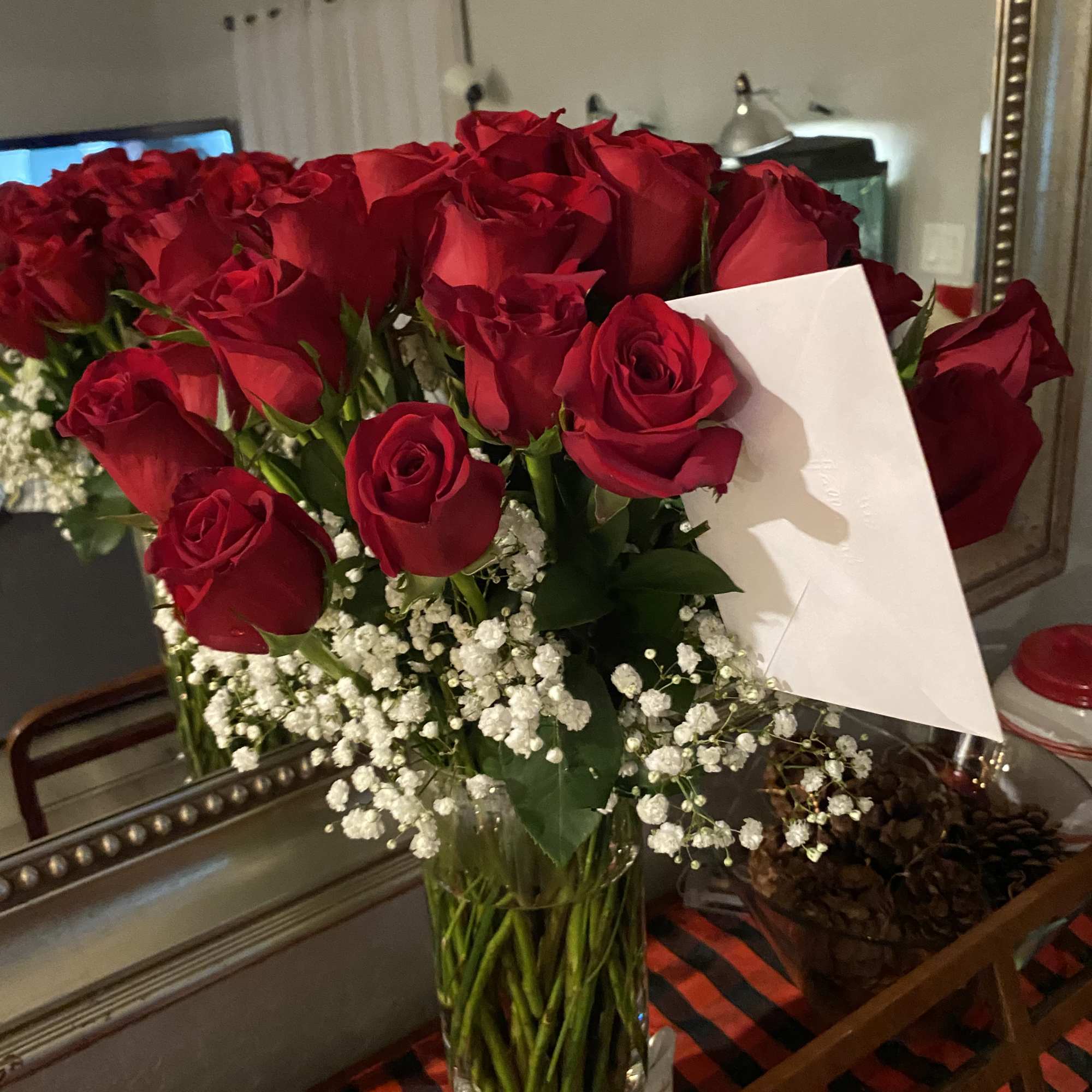 Bouquet of red roses with baby's breath in a clear glass vase
