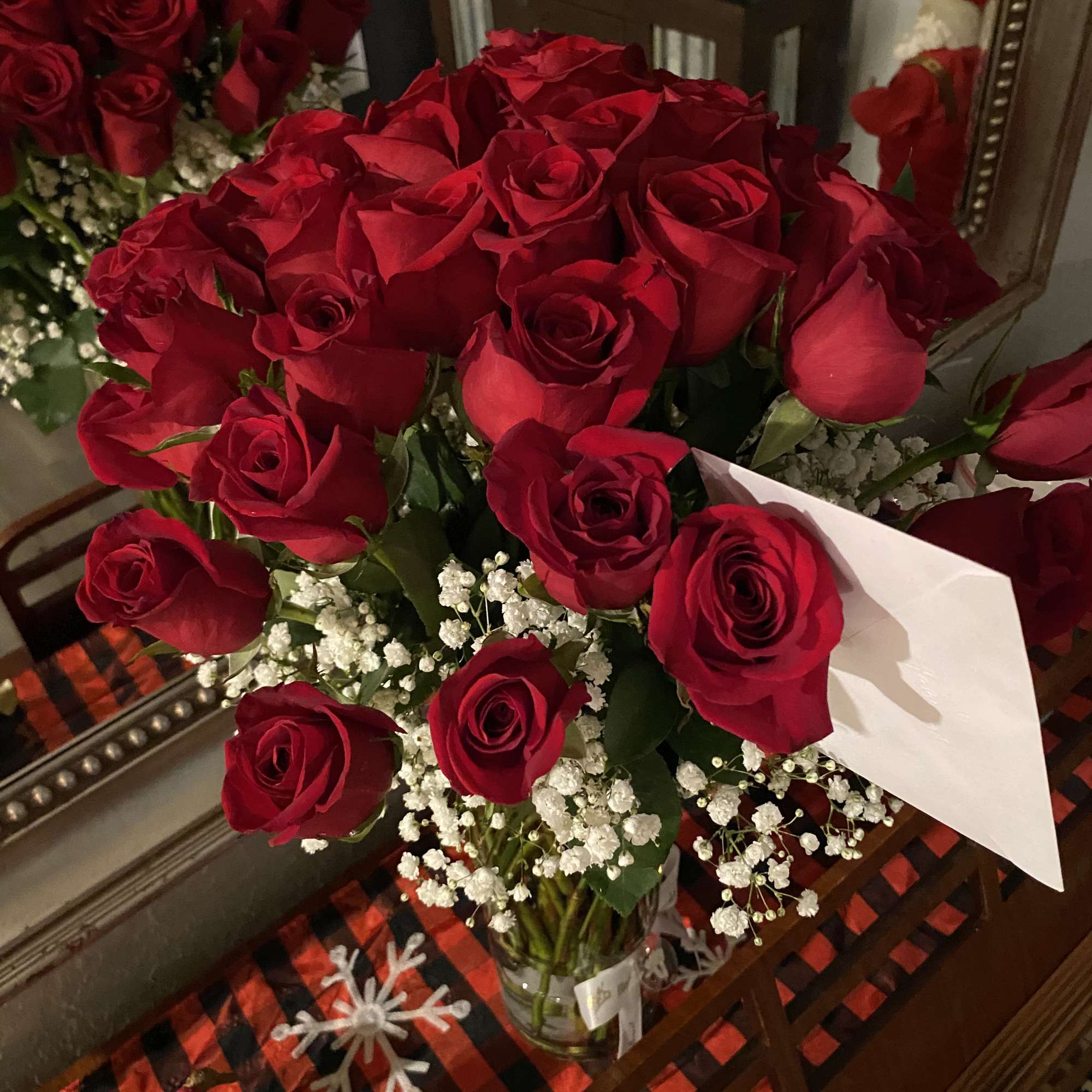 Bouquet of red roses with white baby's breath in a glass vase