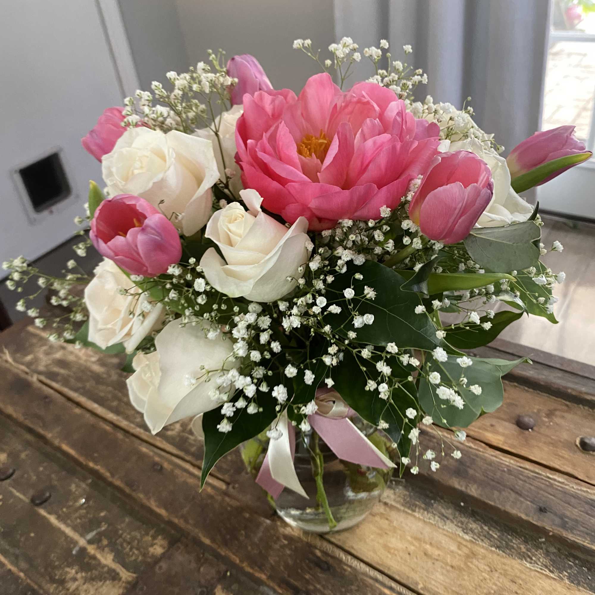 Pink peonies and white roses in a glass vase