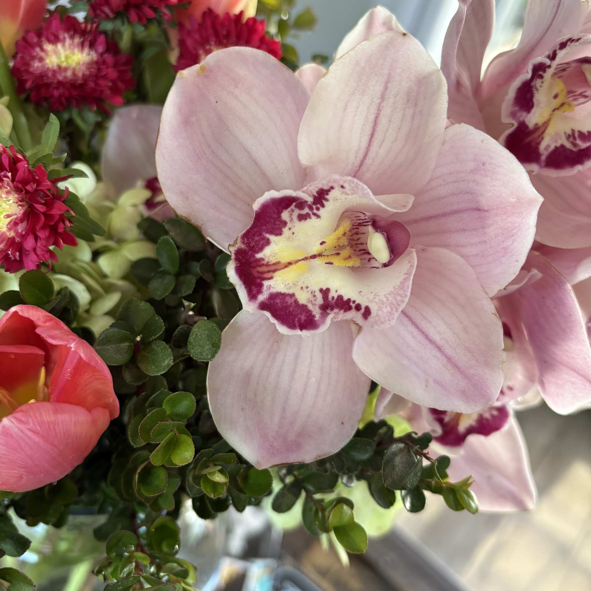 Pink orchids and magenta flowers in a bouquet