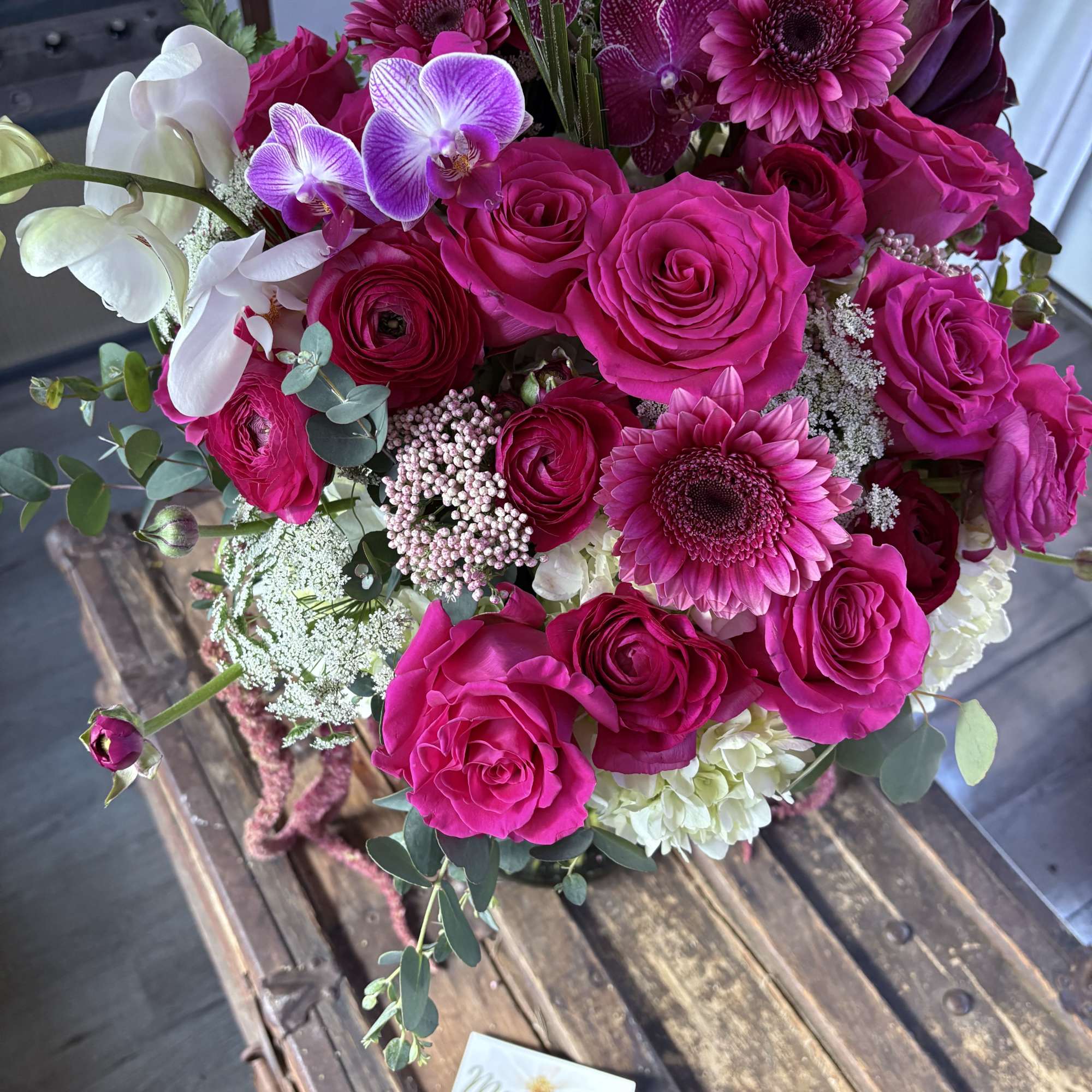 Bright pink bouquet with roses, orchids, and gerbera daisies