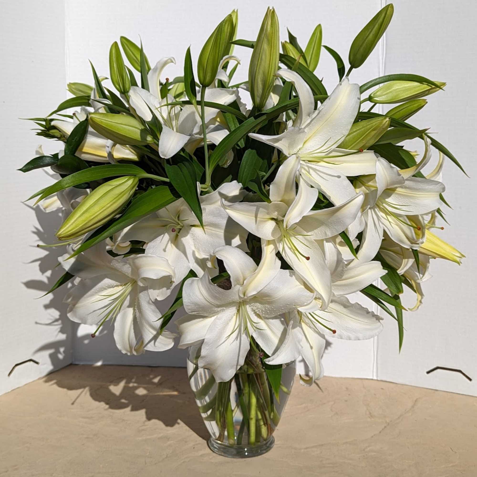 White lilies arranged in a clear glass vase
