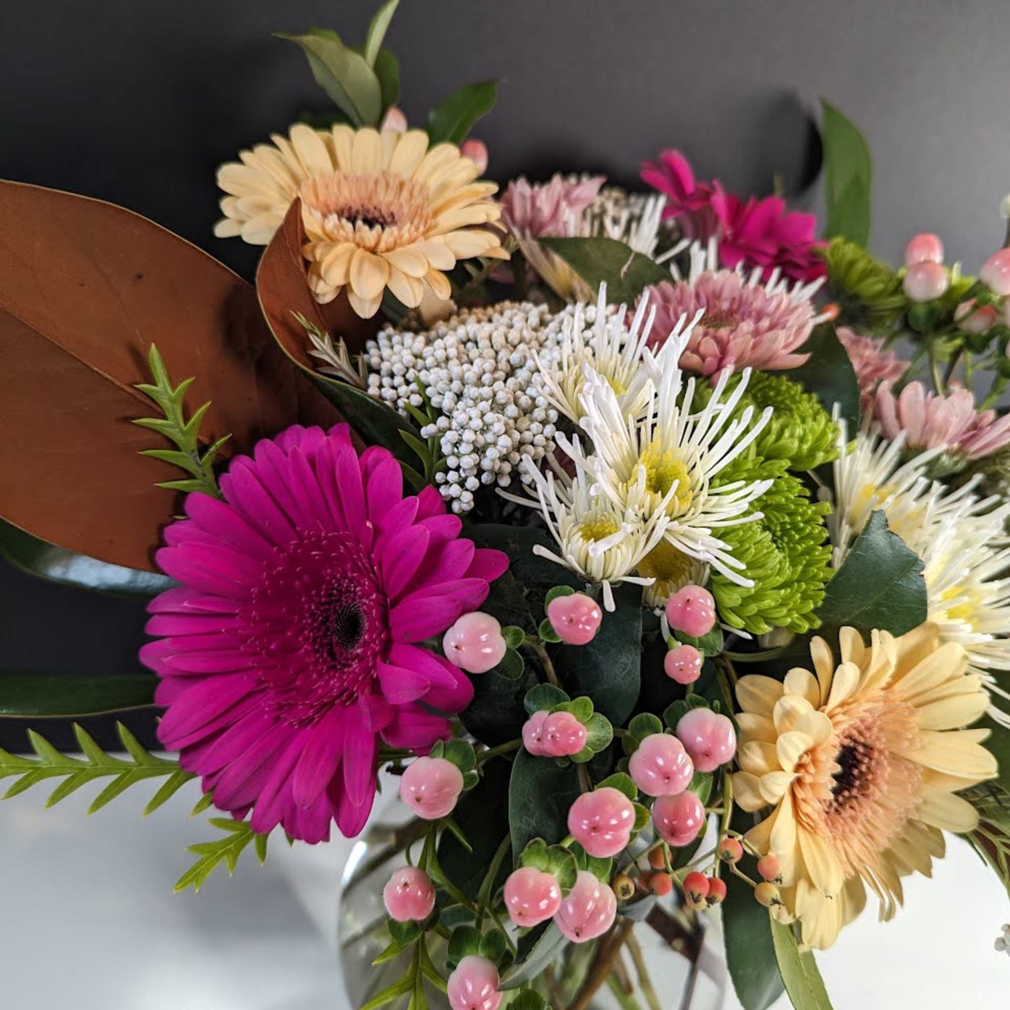 Mixed bouquet with pink and cream daisies in a glass vase