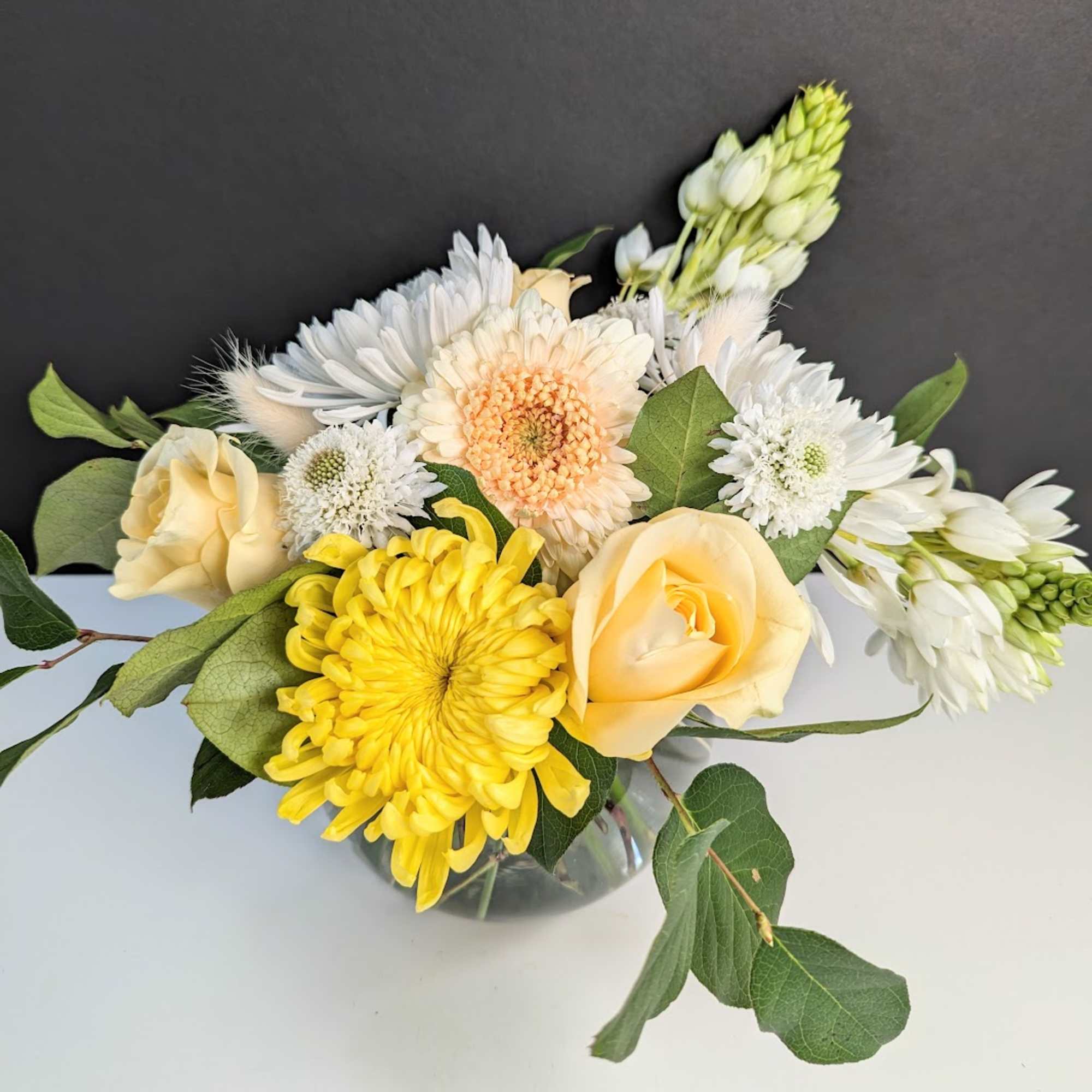 Yellow and white mixed flowers in a glass vase