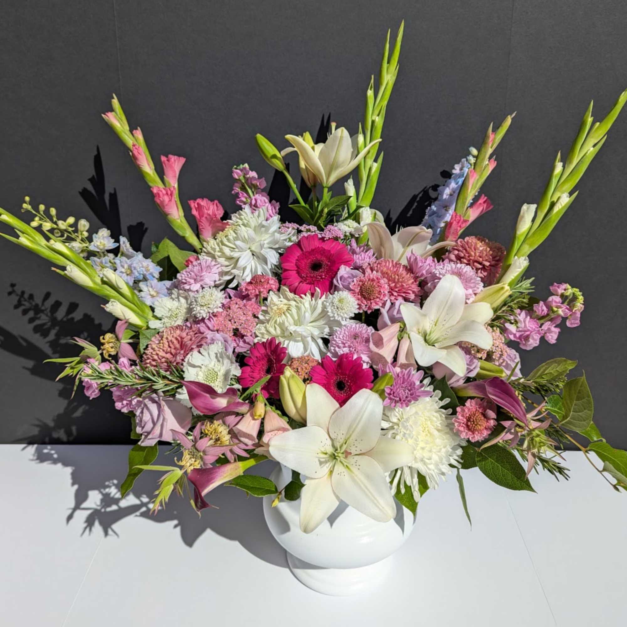 Mixed pink and white floral arrangement in a white vase