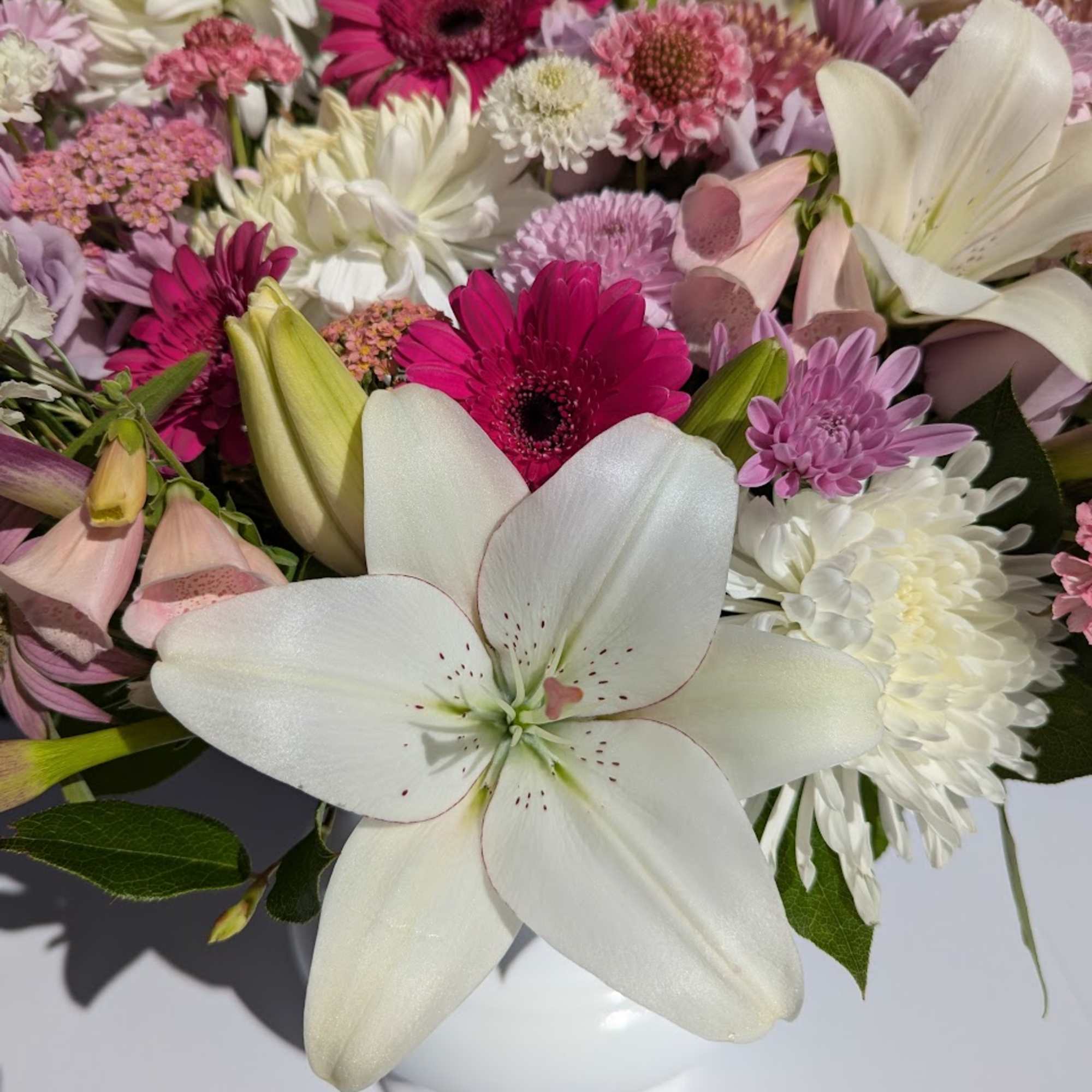 Mixed bouquet with white lilies, pink gerberas, and white chrysanthemums in a vase