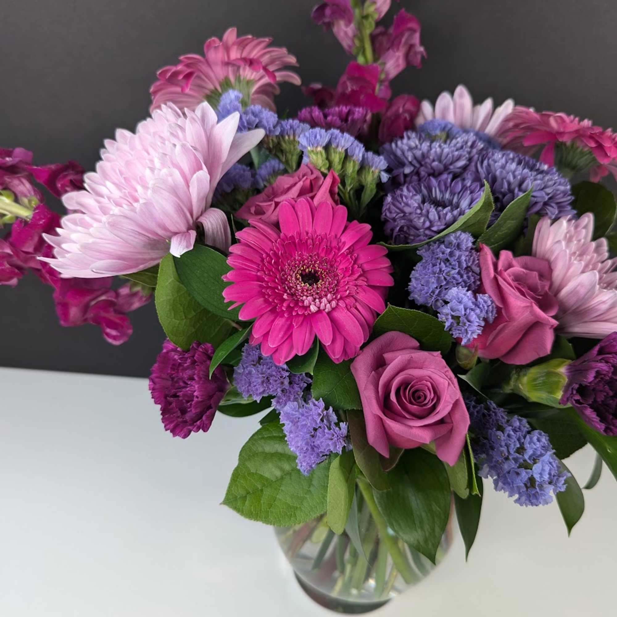 Pink and purple mixed bouquet in a clear glass vase, photo 2 of 3