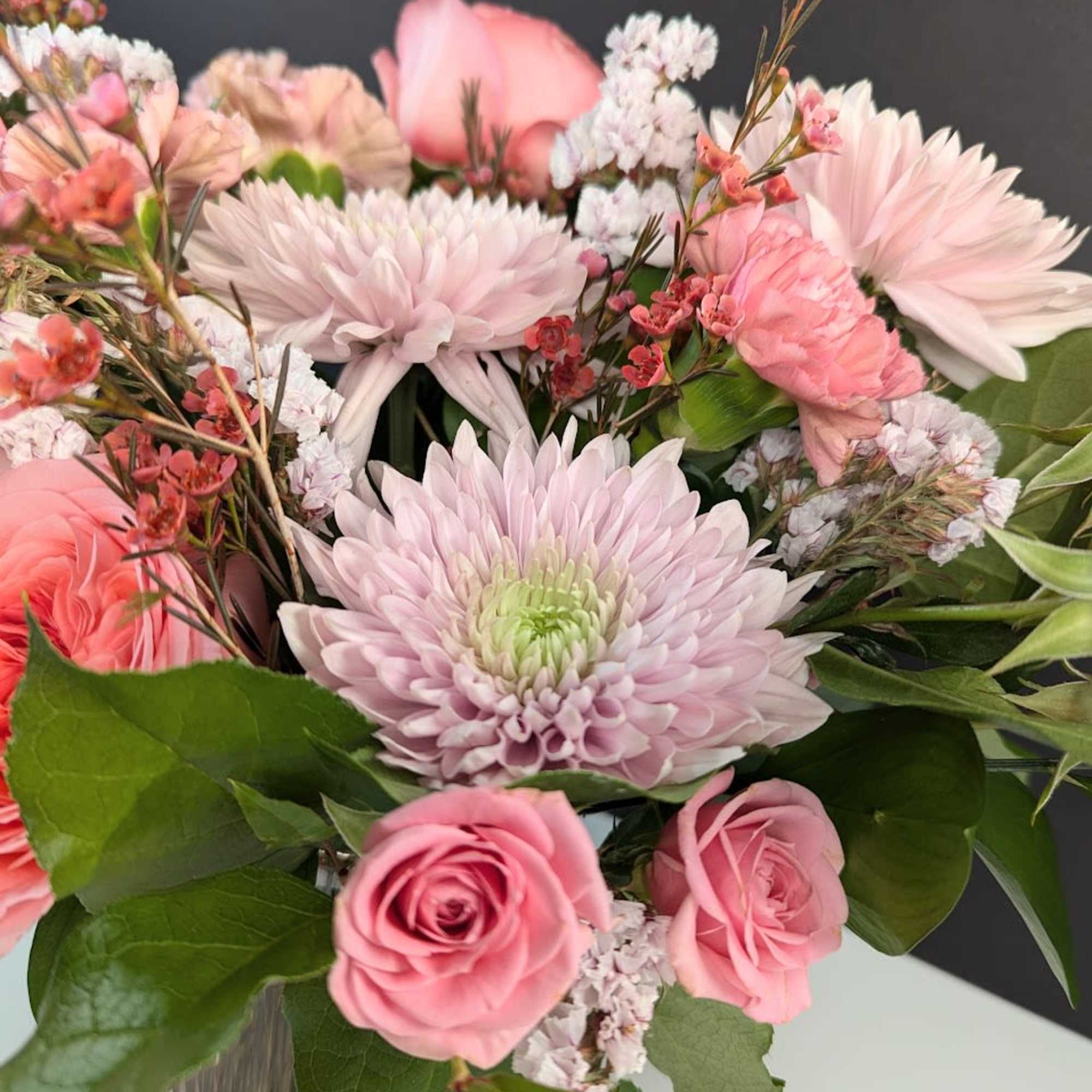 Pink roses and pale chrysanthemums in a glass vase