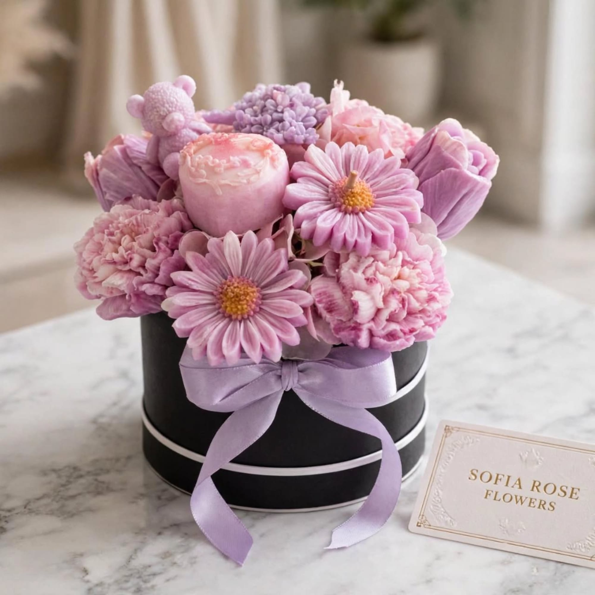 Pink and lavender flowers arranged in a black round box with a ribbon, photo 5 of 9
