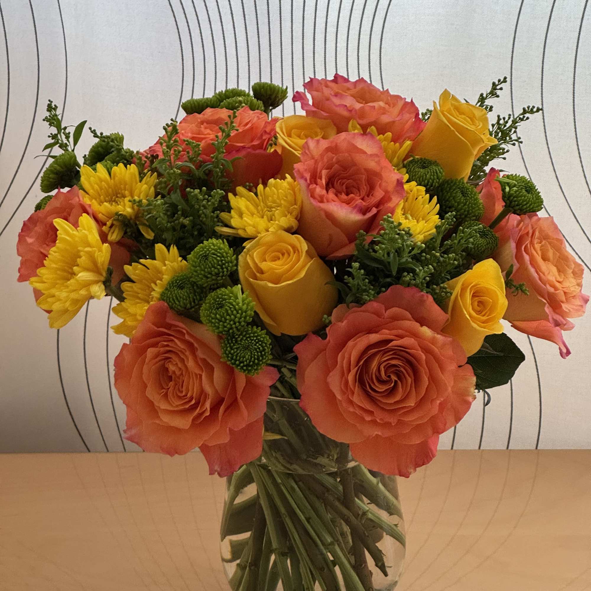 Bouquet of orange and yellow roses with yellow chrysanthemums in a glass vase, photo 3 of 7