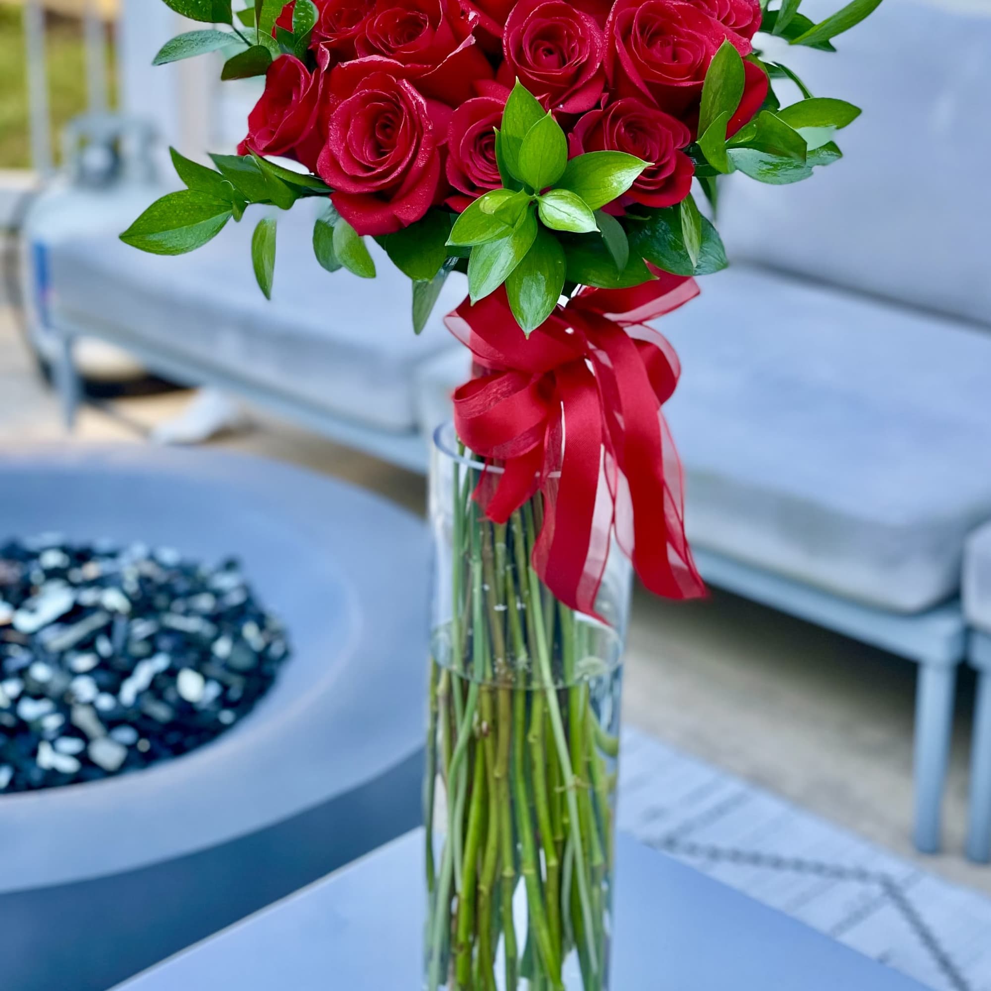 Red rose bouquet in a tall glass vase with a red ribbon, photo 2 of 3