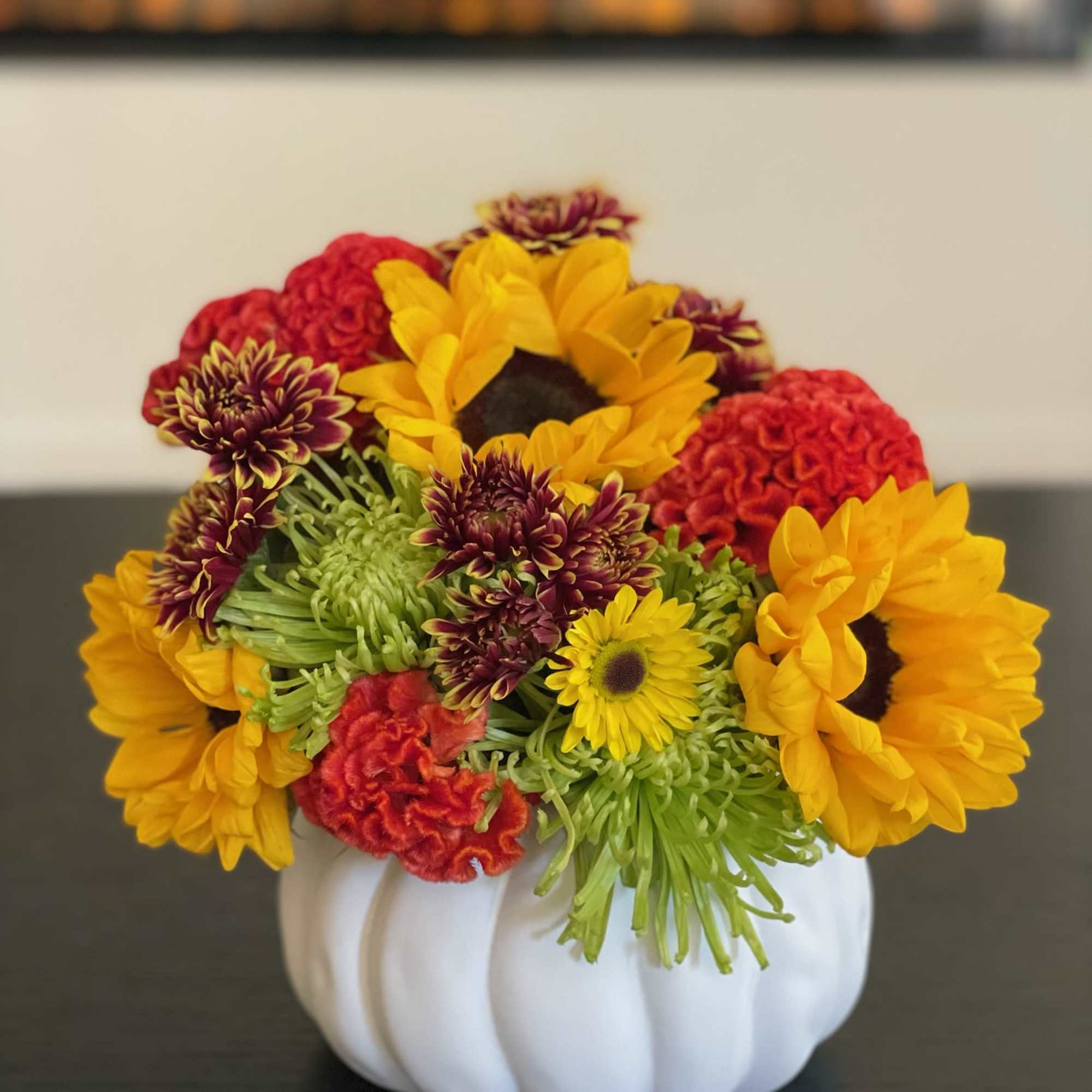 Mixed flowers arranged in a white pumpkin-shaped vase
