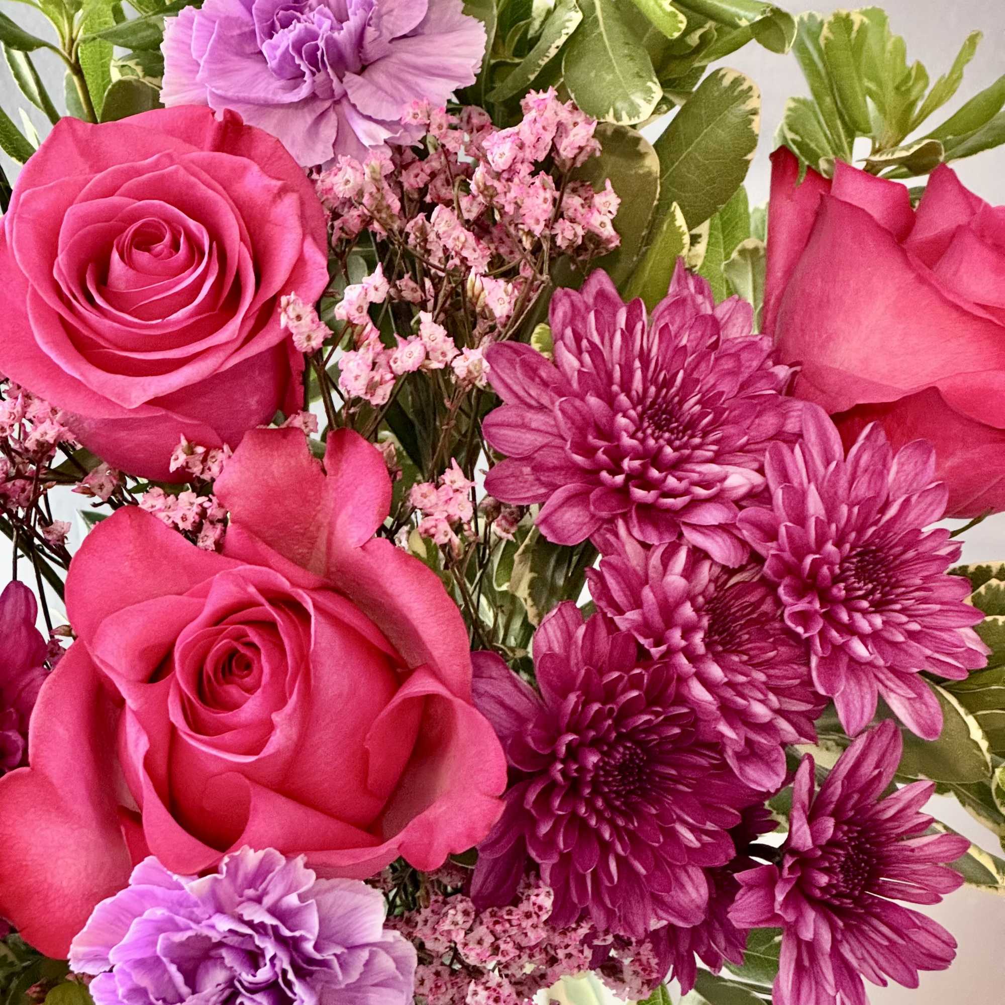 Bouquet of hot pink roses, purple carnations, and magenta chrysanthemums