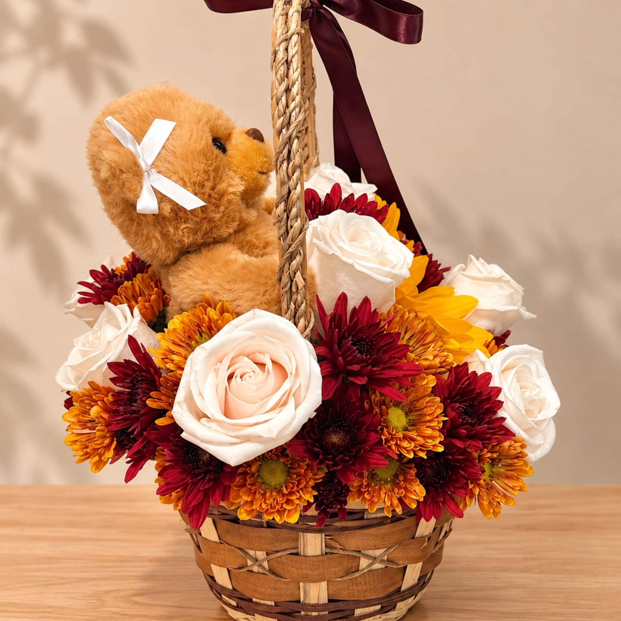 Basket arrangement with a teddy bear and white roses in red and yellow flowers