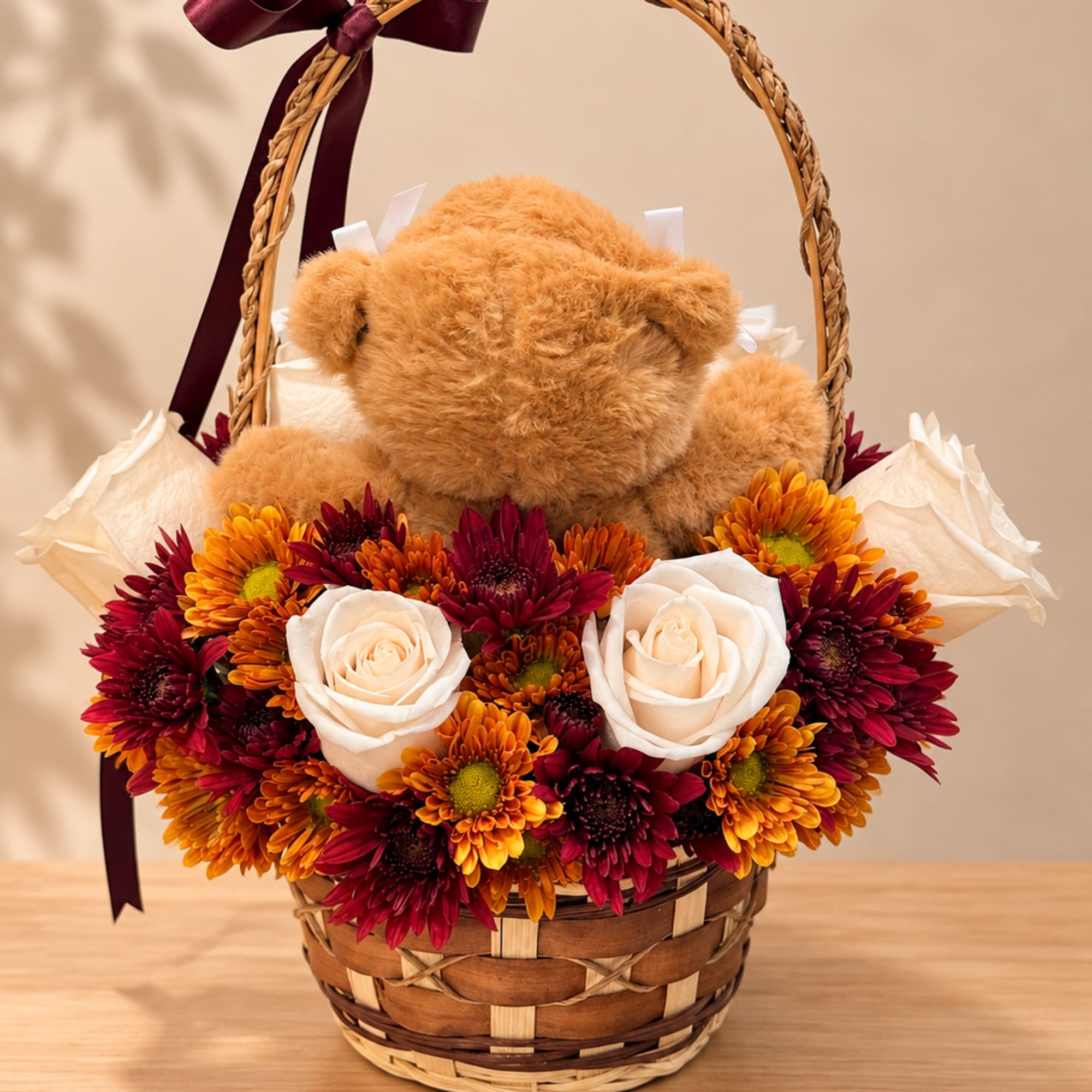 Teddy bear in a wicker basket surrounded by white roses and chrysanthemums