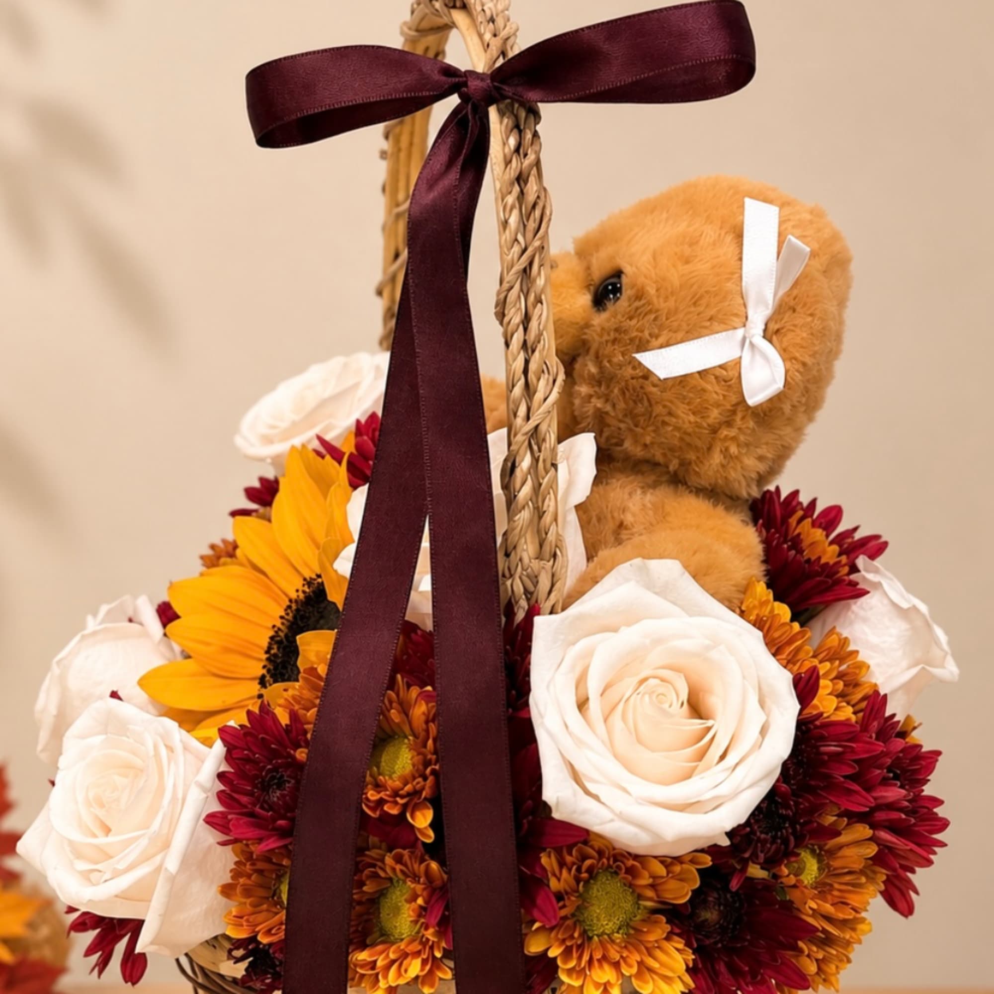 Teddy bear in a basket with white roses and yellow-red flowers