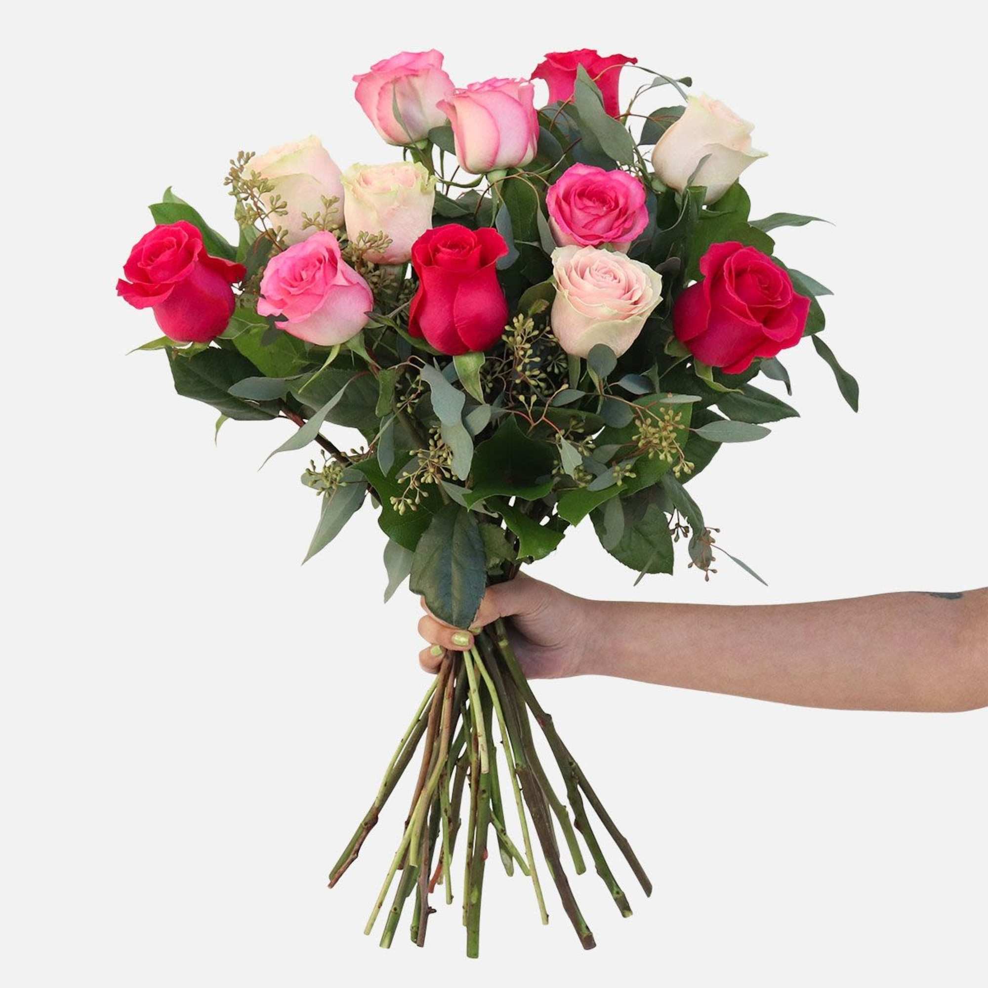 Handheld bouquet of pink and red roses with greenery