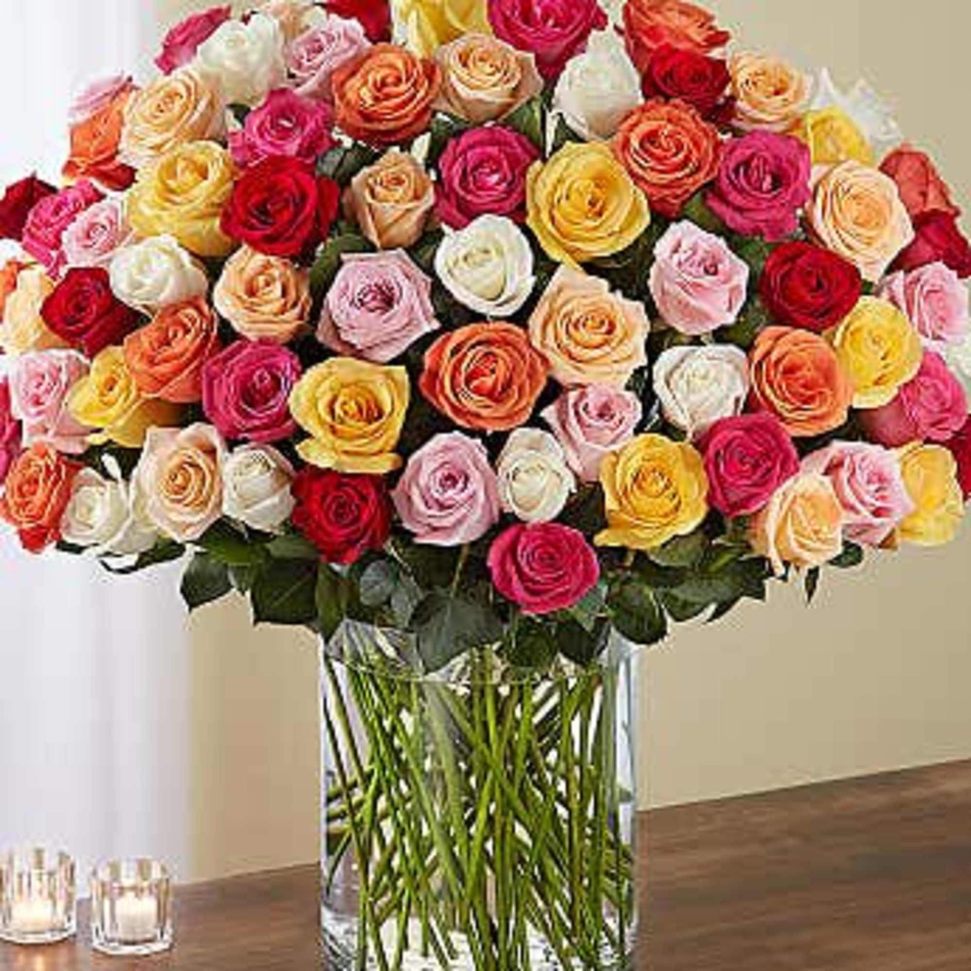 Large bouquet of multicolored roses in a clear glass vase