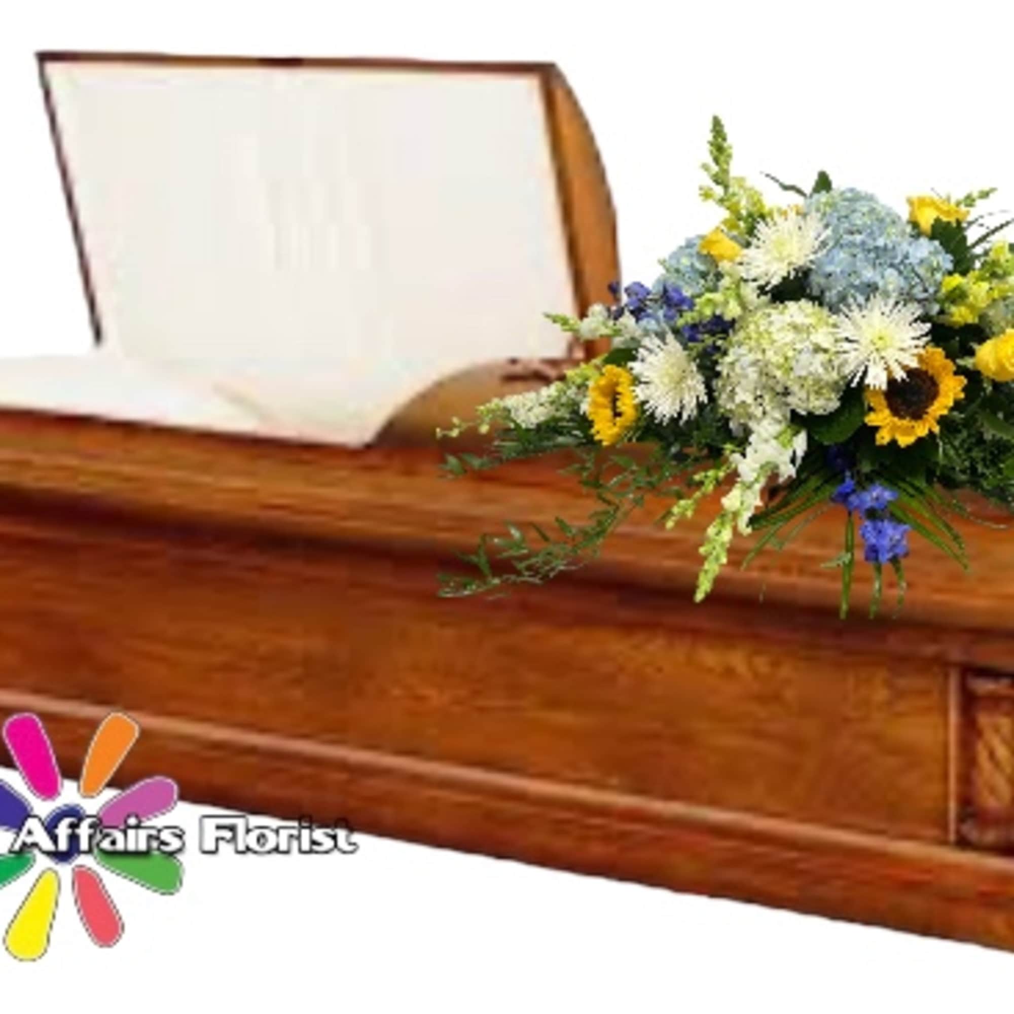 Wooden casket with a mixed floral spray on top