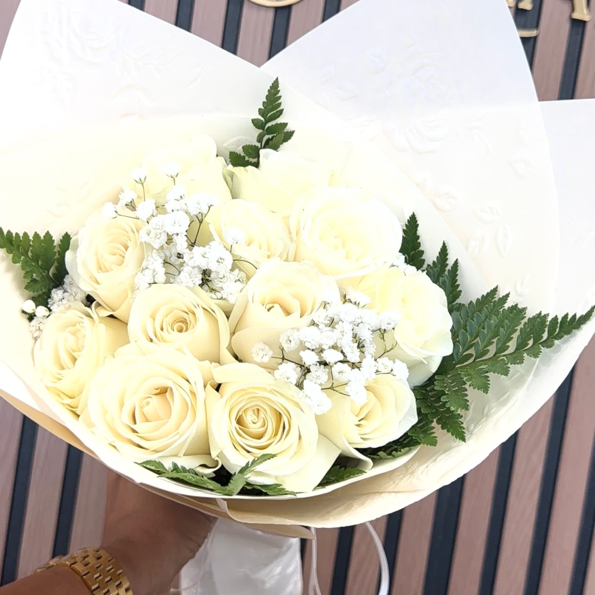 Bouquet of cream roses with white baby's breath in white wrapping