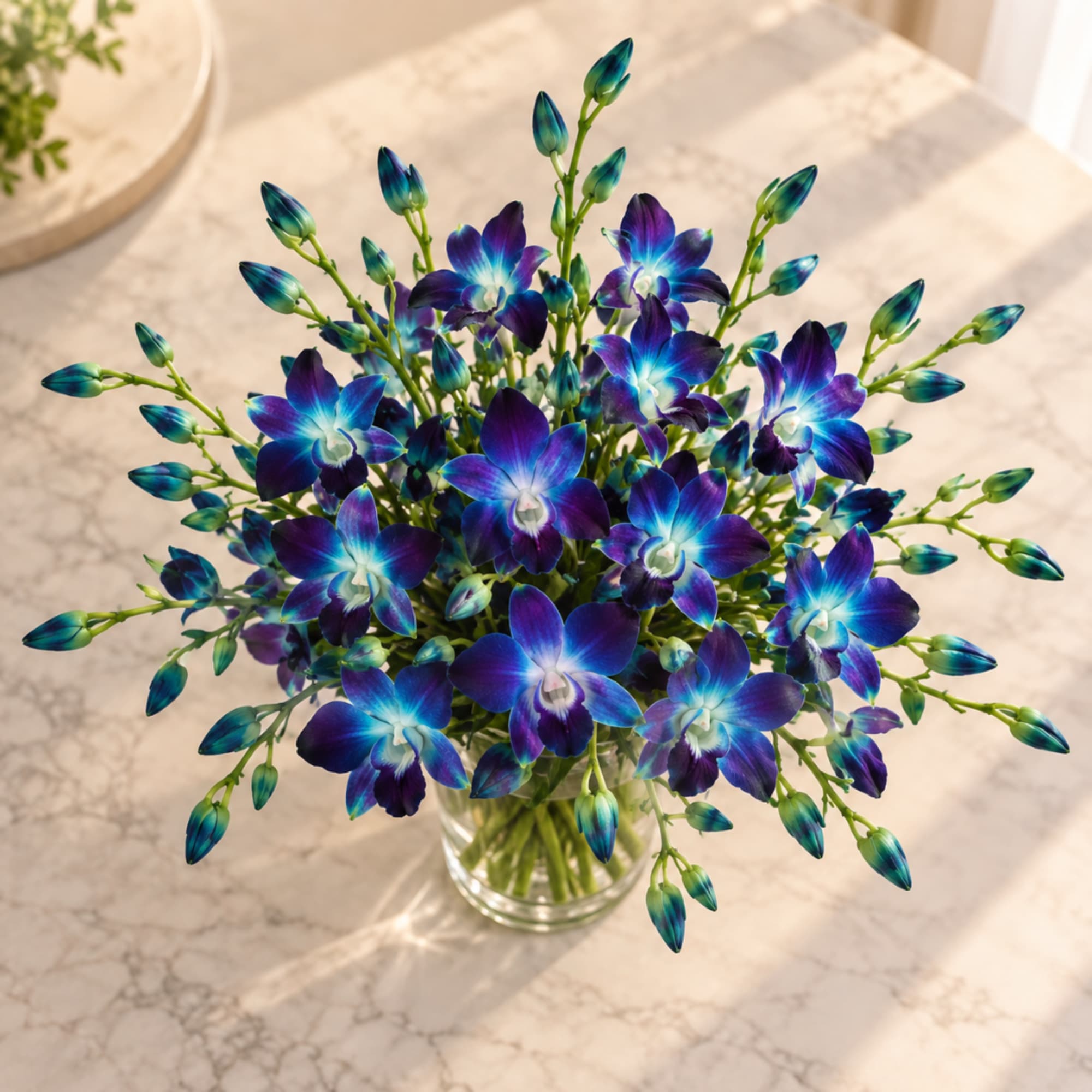 Blue-purple orchid bouquet in a clear glass vase