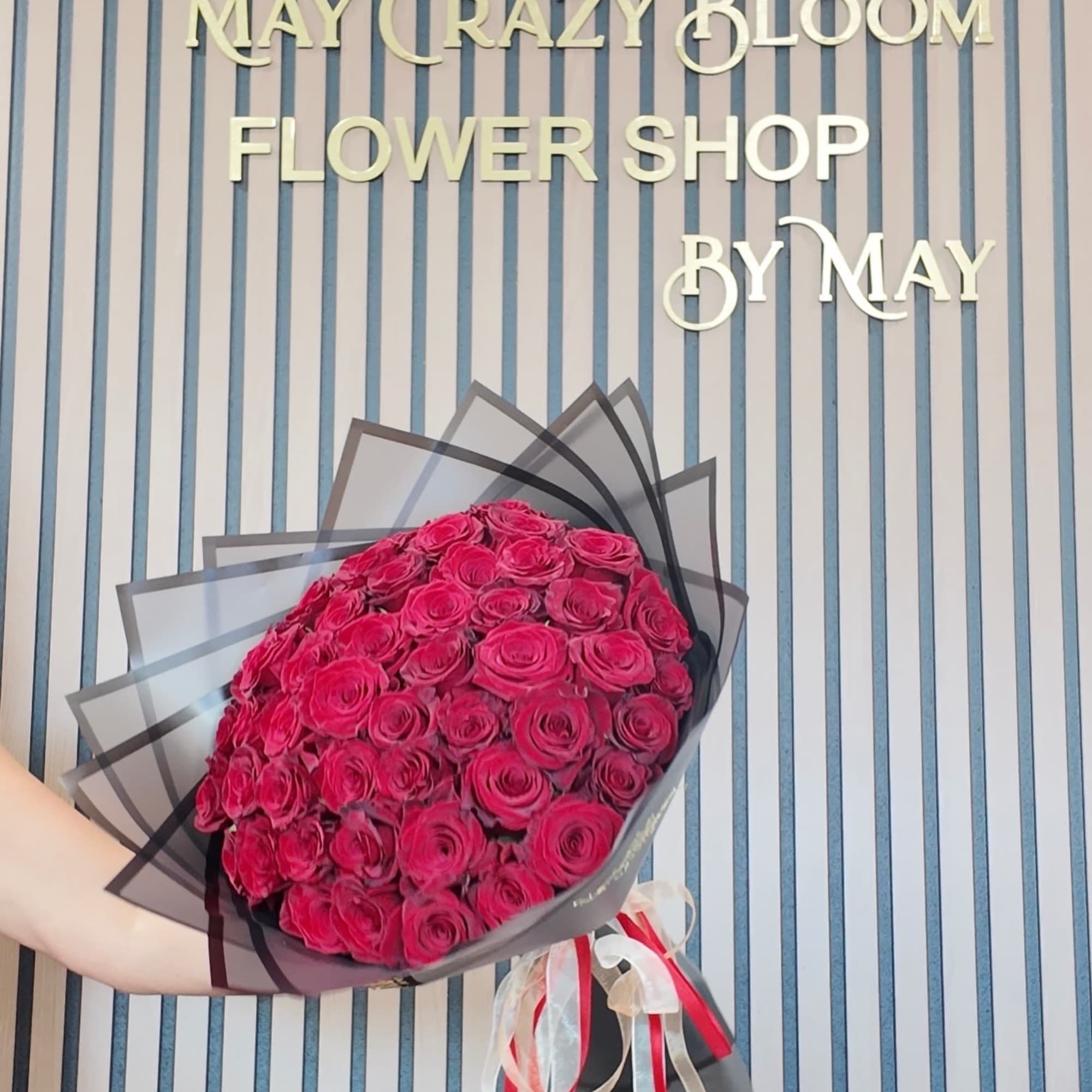 A lush dome of 36 tightly packed roses in saturated pink-red tones