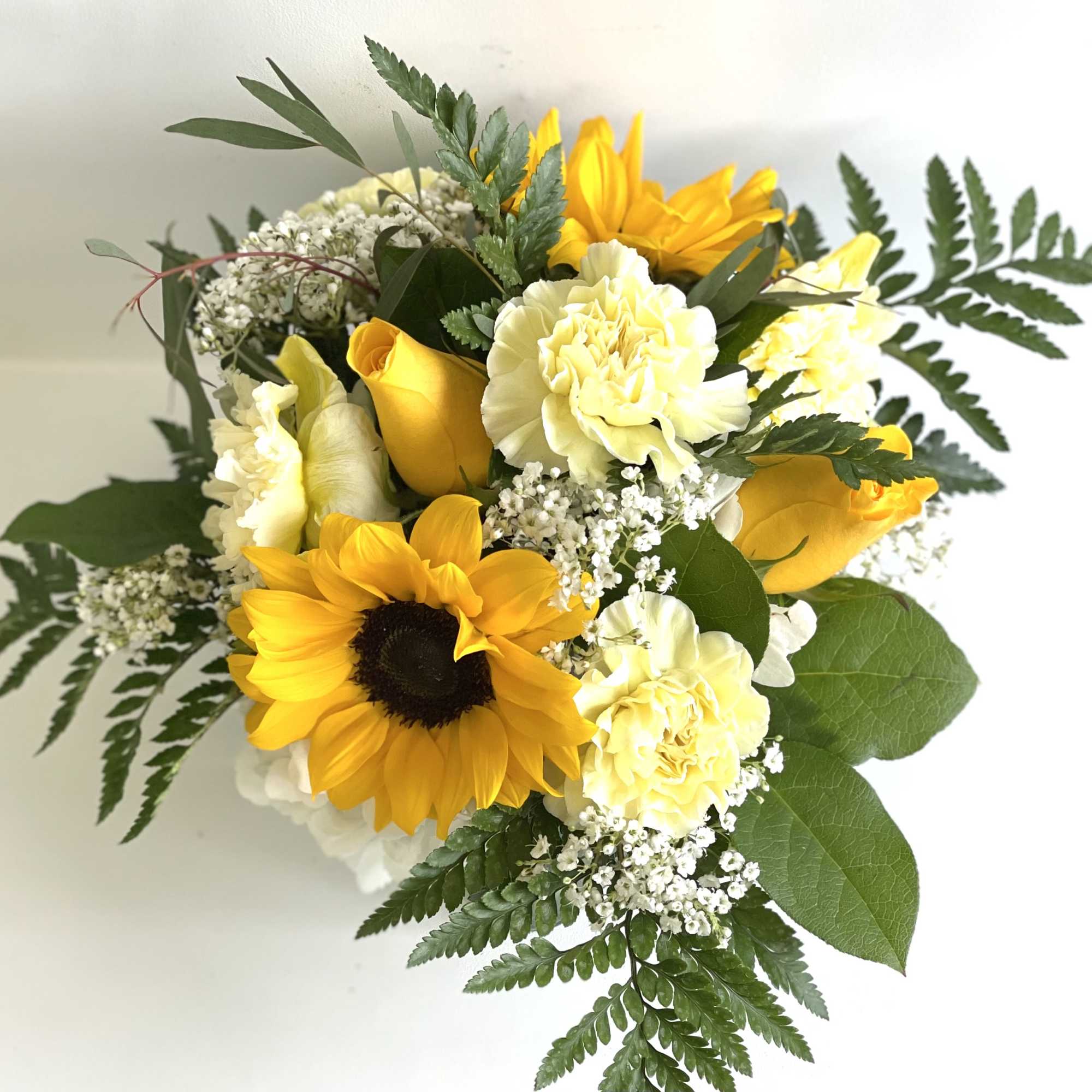 Bouquet of yellow sunflowers and pale cream carnations with white filler flowers