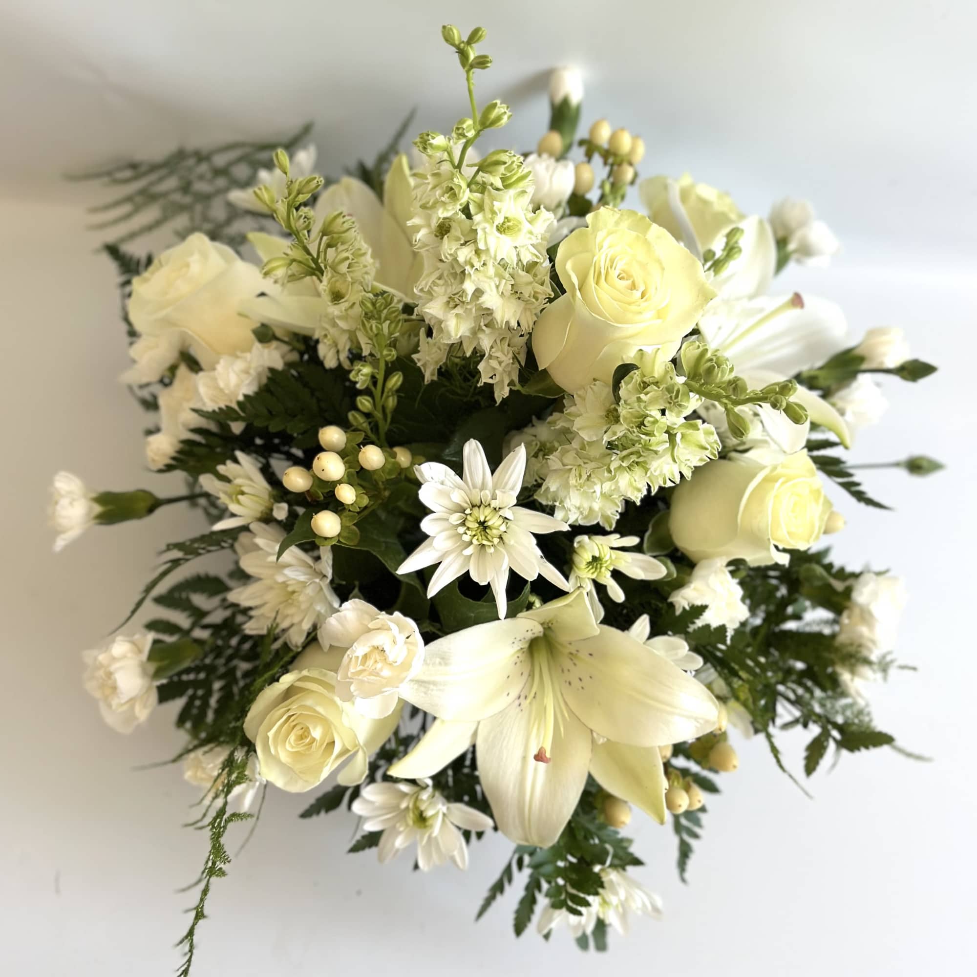 Creamy white bouquet with roses, lilies, and daisies