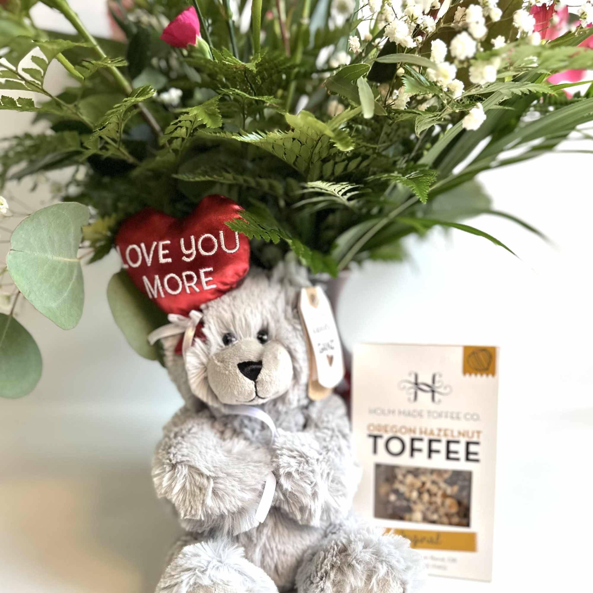 Bouquet with pink and white flowers, a teddy bear, and a toffee box