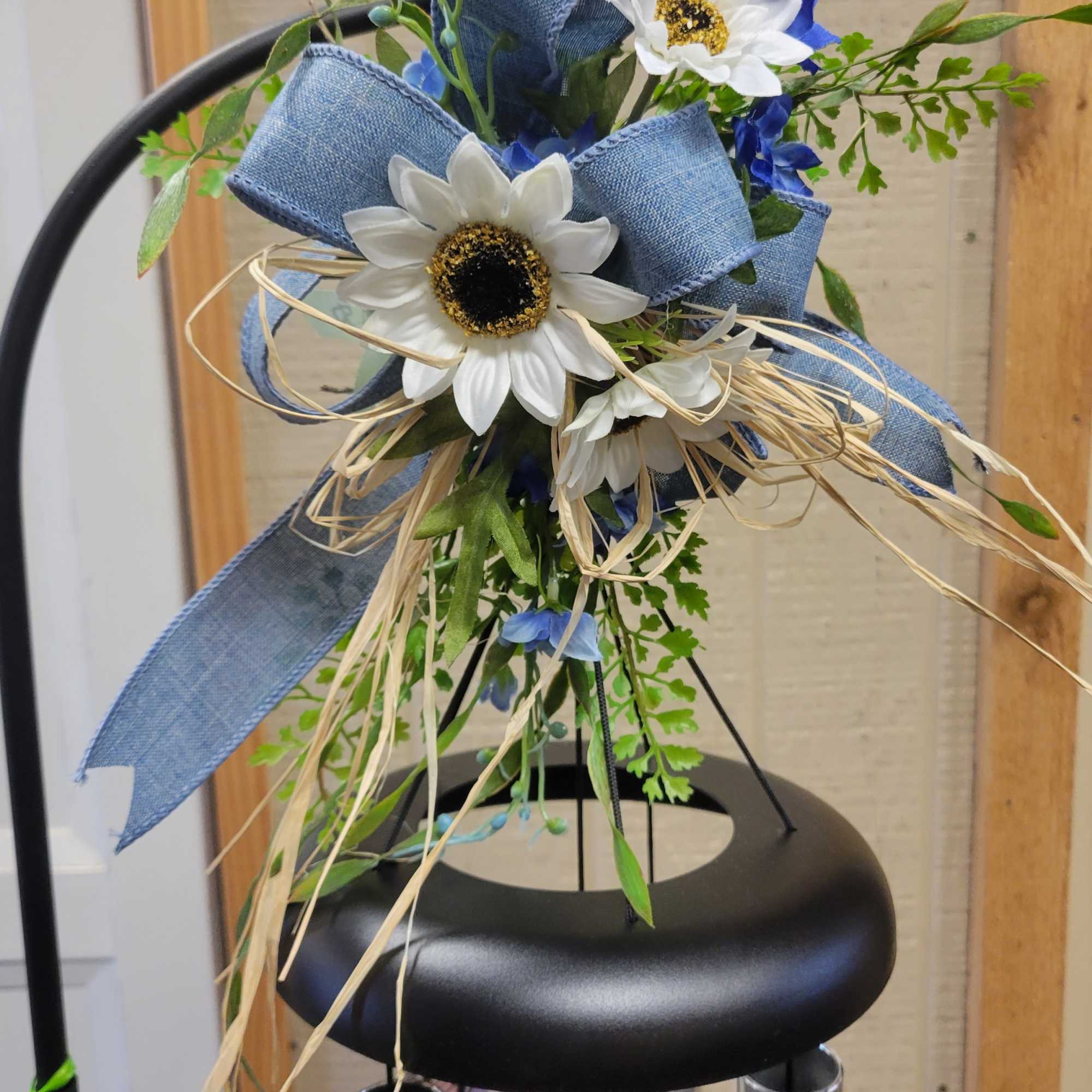 Blue and white artificial flower arrangement with ribbon and straw accents