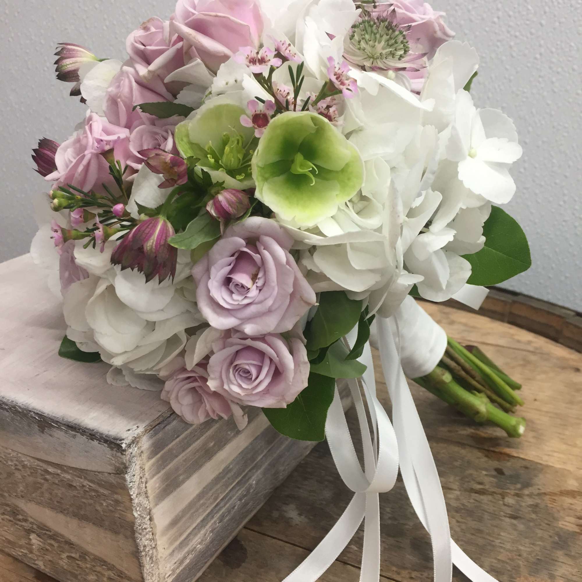 Bouquet of pale pink and white flowers with a white ribbon