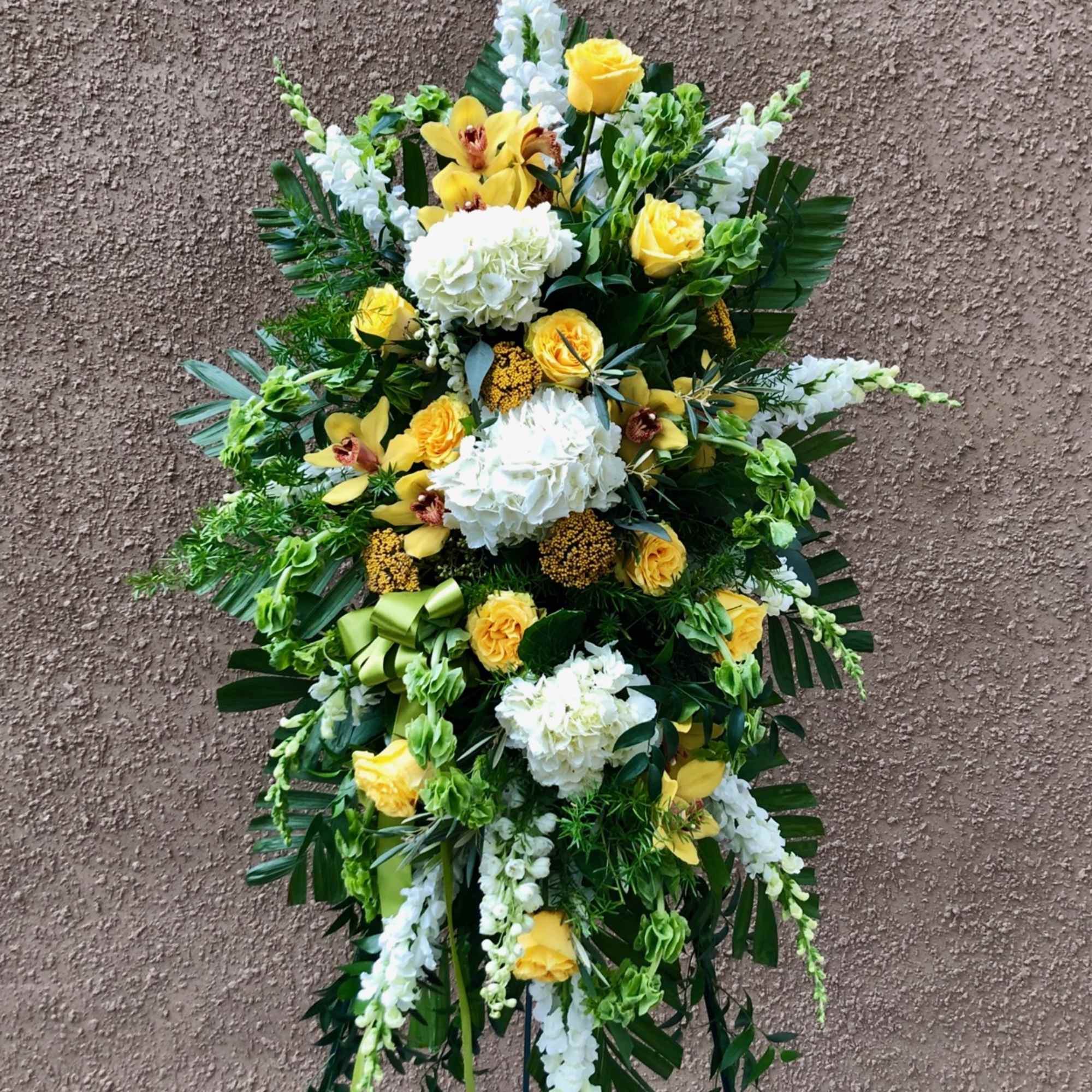 Tall standing floral spray with yellow roses and white blooms