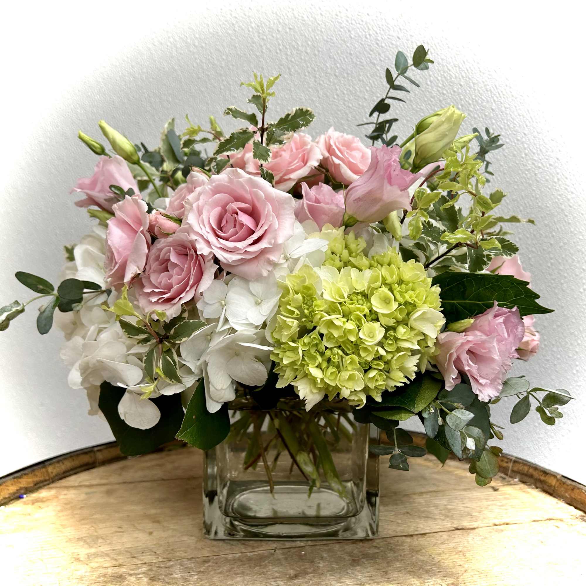 Pink roses and white hydrangeas in a clear glass vase