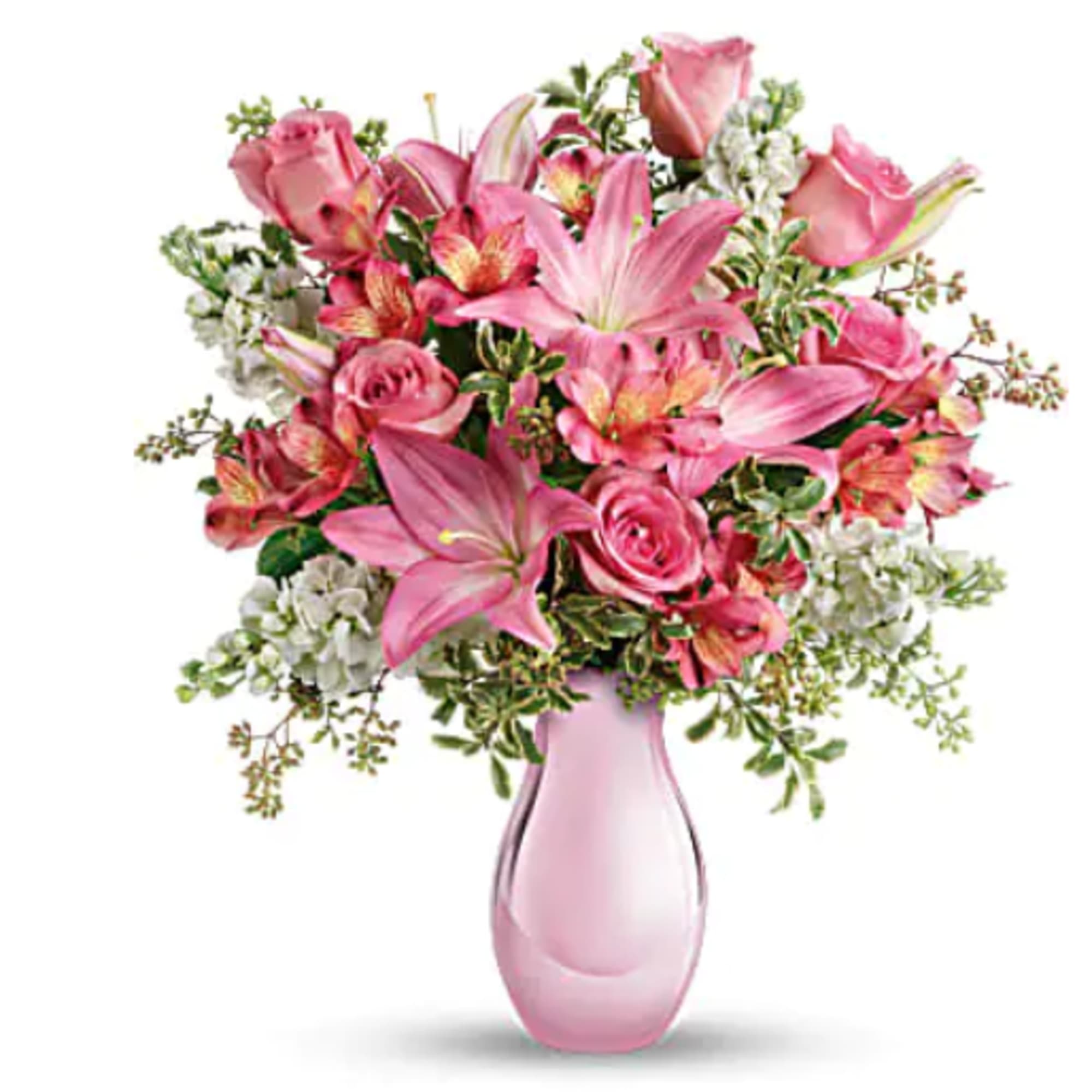 Pink lilies, roses, and alstroemeria arranged in a light pink glass vase