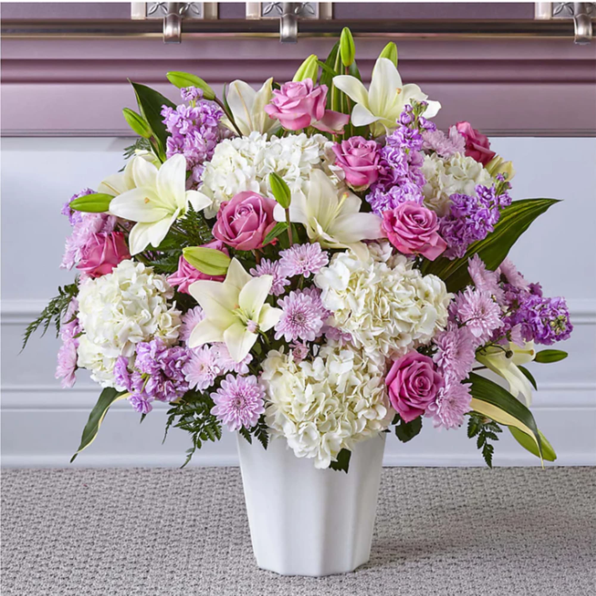 Pink roses and white lilies in a white vase