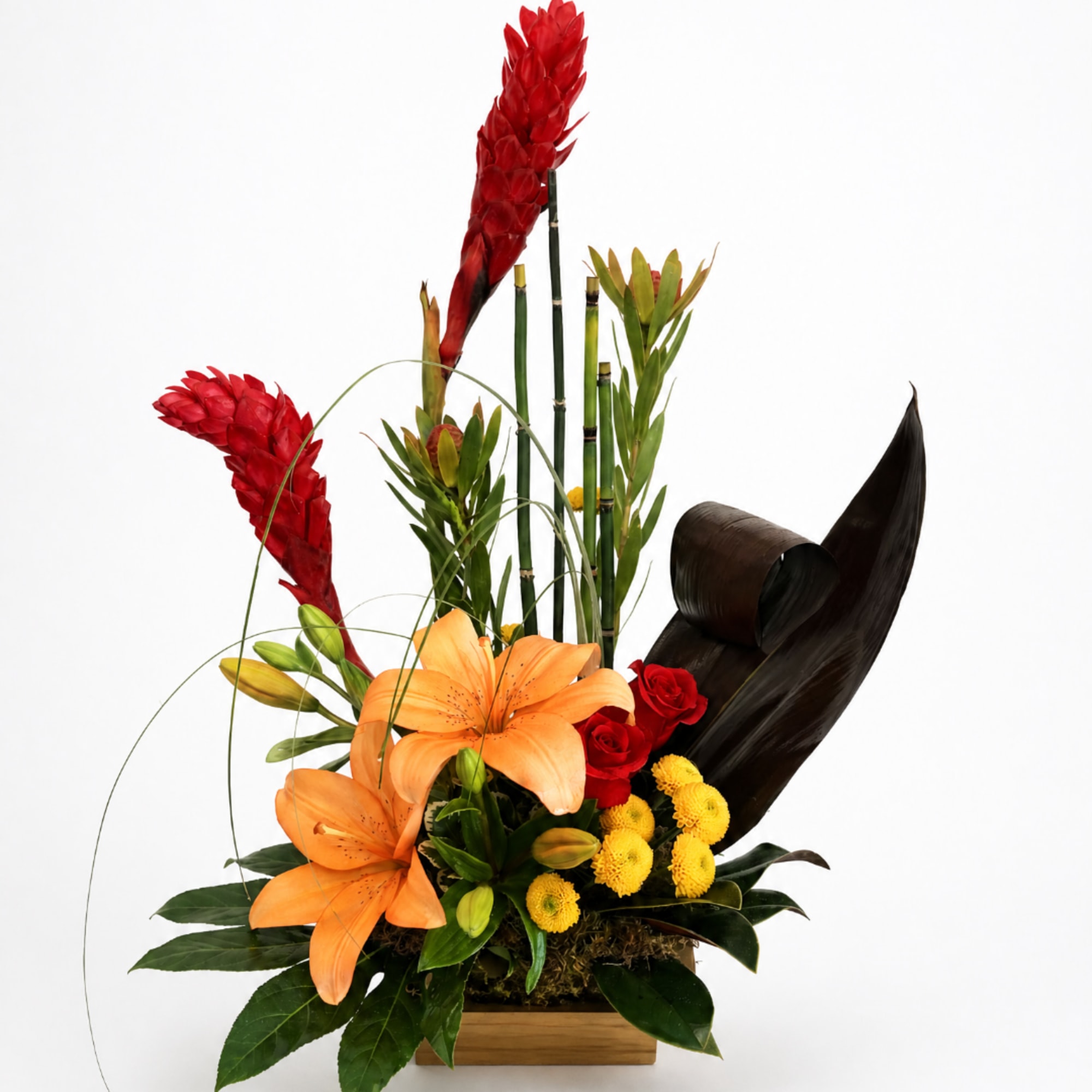 Tropical flower arrangement with orange lilies, red blooms, and yellow button flowers in a wooden container