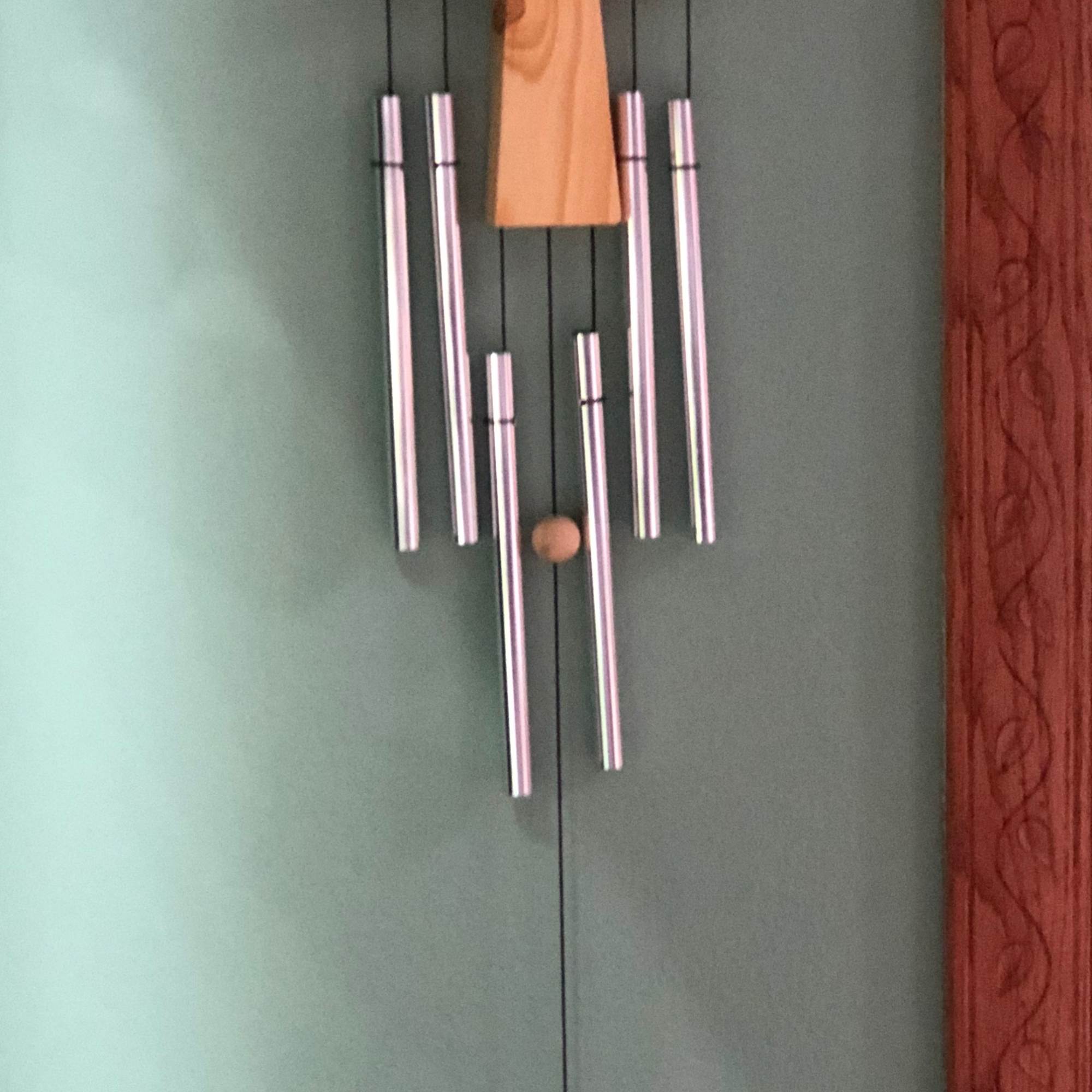 Wooden cross wall hanging with silver wind chimes
